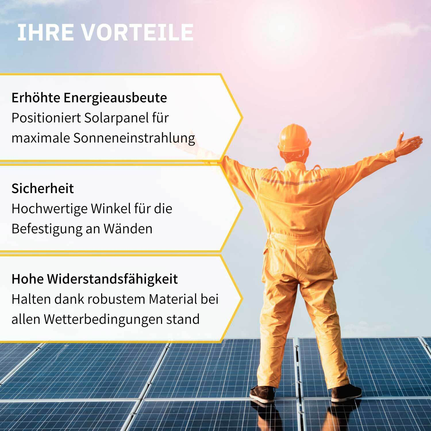 Mann in orangefarbener Arbeitskleidung steht auf Solarpanels, Arme ausgebreitet.