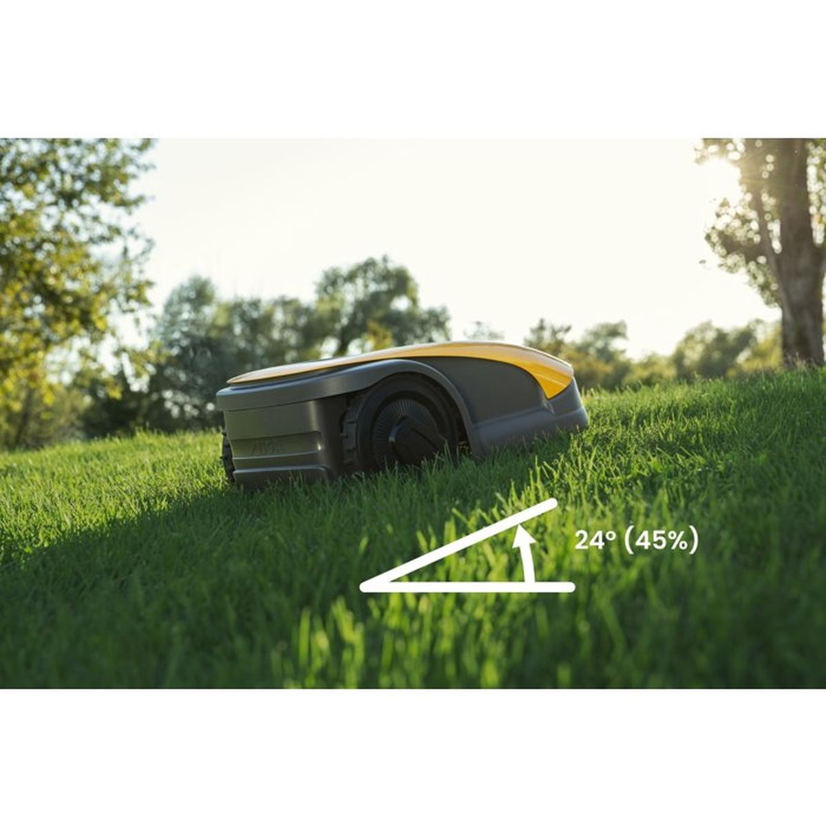 Ein Mähroboter auf einer grünen, geneigten Rasenfläche im Sonnenlicht.