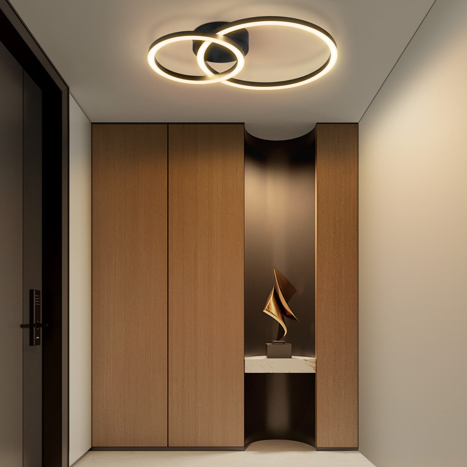 Un corridoio con mobili in legno, una scultura e una lampada ad anello sul soffitto.