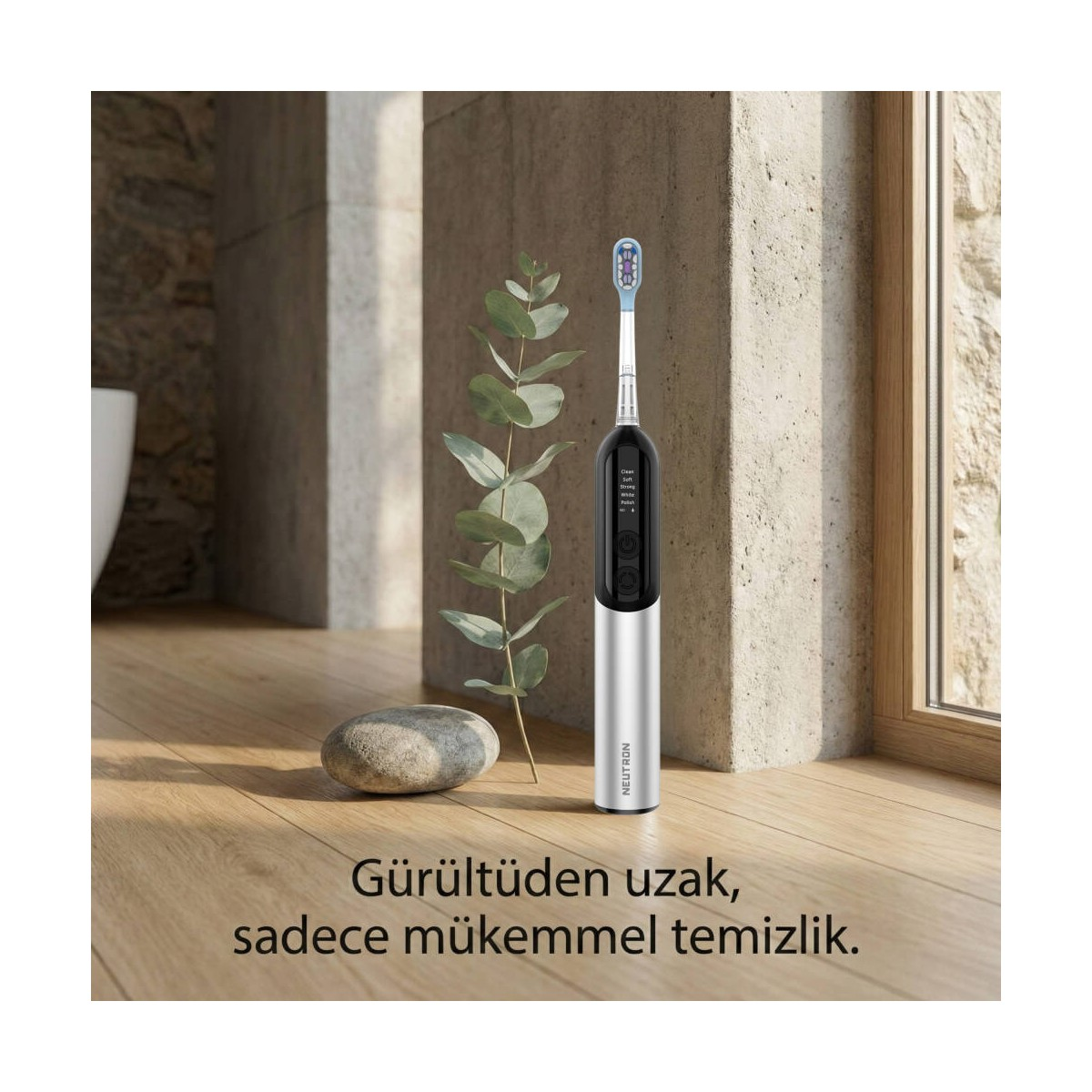 Ahşap zeminde bitki ve taş yanında elektrikli diş fırçası.