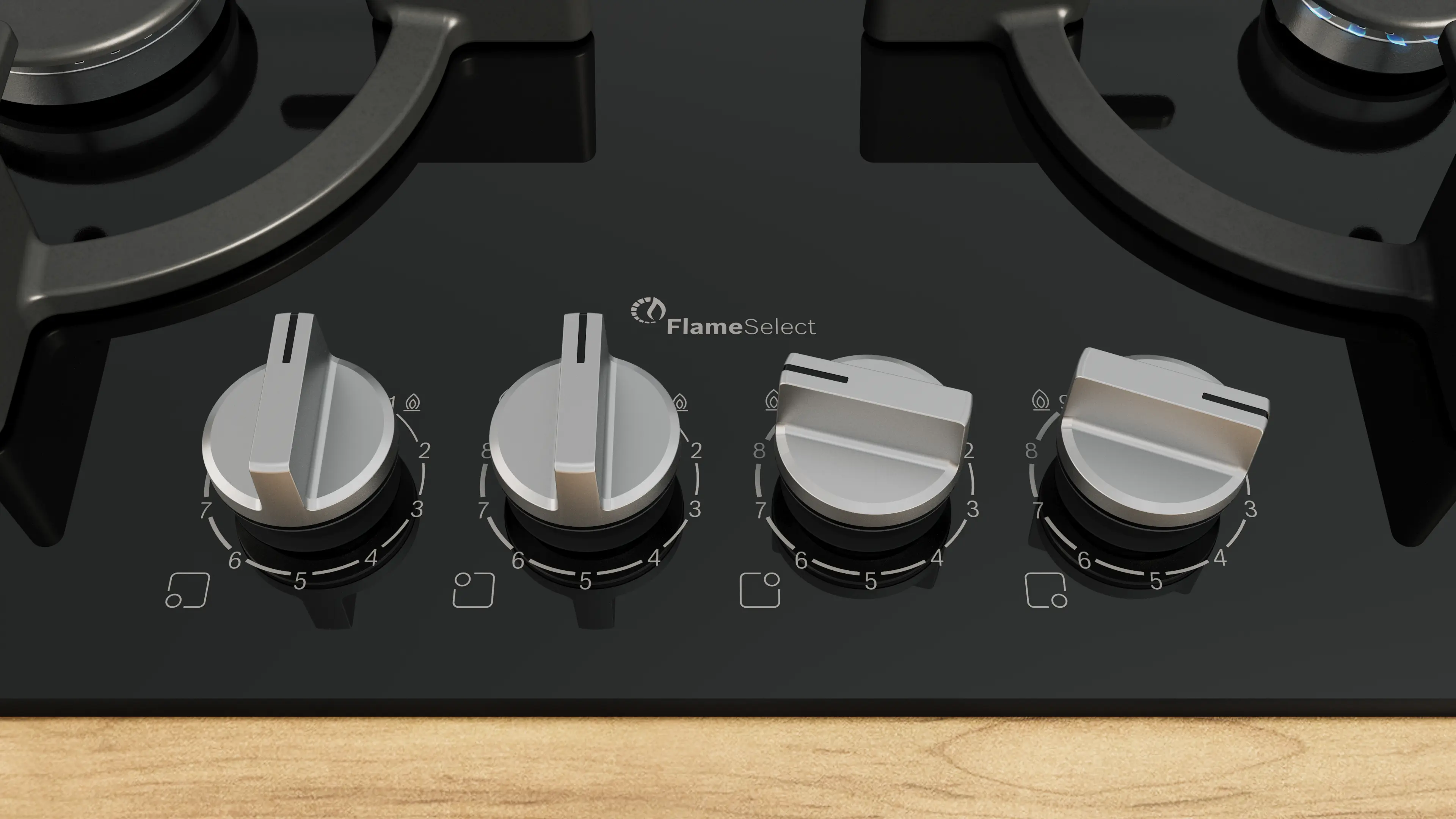 Primer plano de una estufa de gas negra con cuatro perillas plateadas y el logo Flame Select.