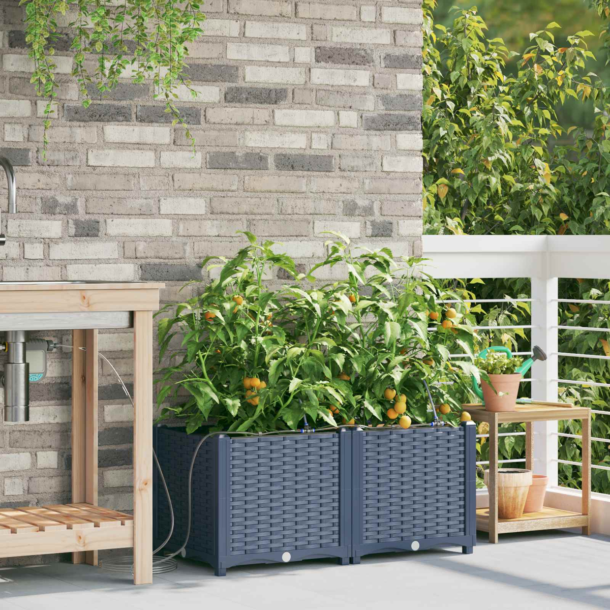 Una fioriera con piante di pomodoro si trova su un balcone accanto a un tavolo di legno.
