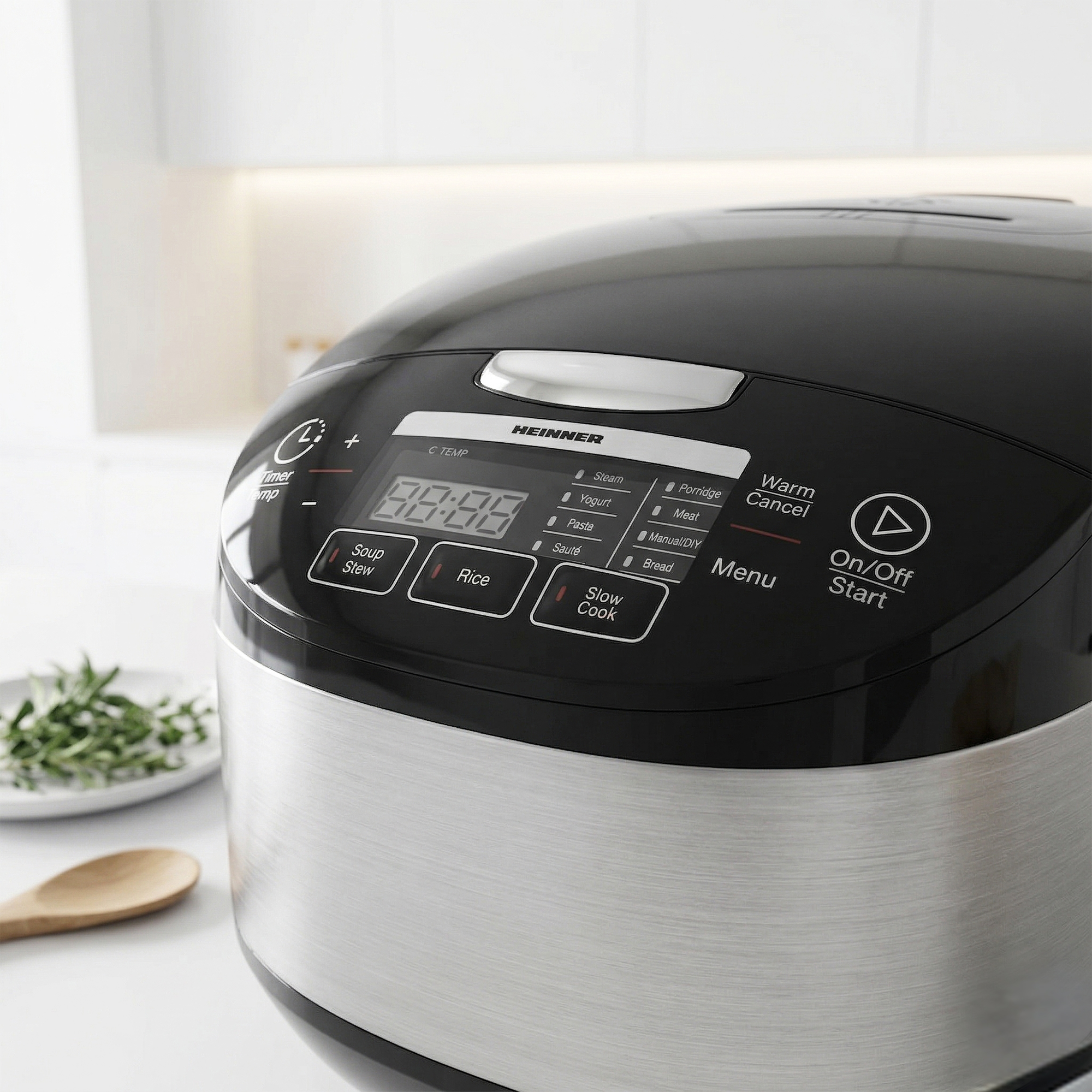 A black Heinner rice cooker with a silver body and a digital display panel.