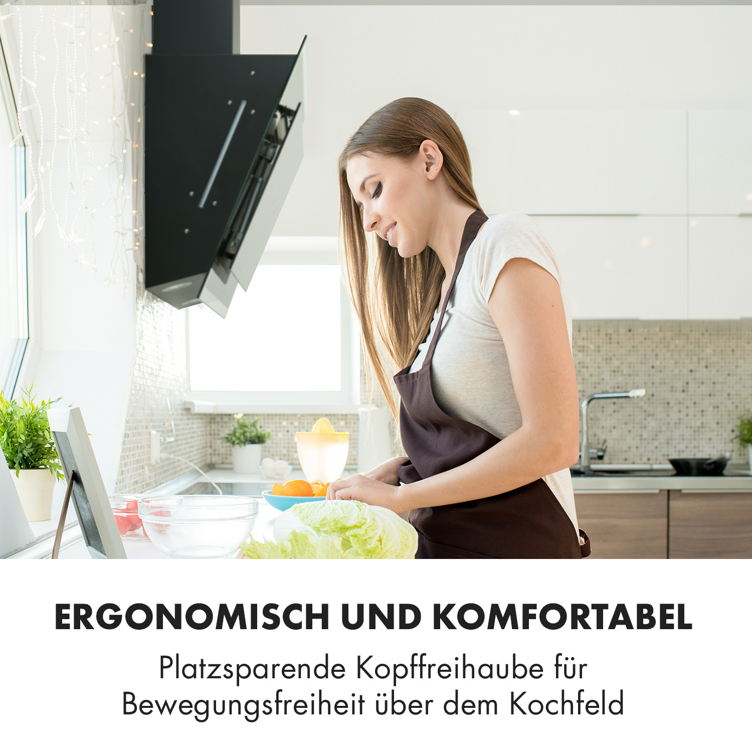 Eine Frau mit Schürze bereitet in einer Küche Salat zu.