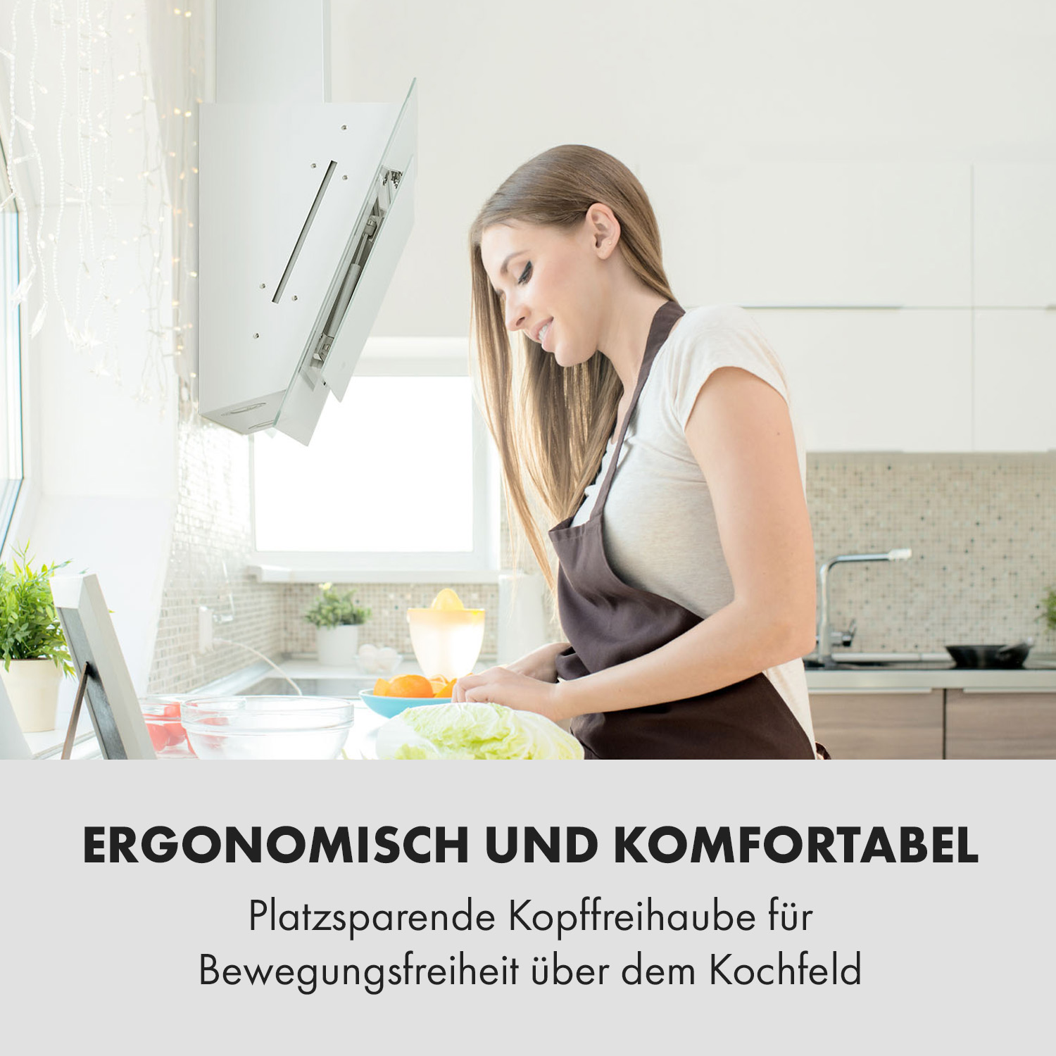 Una mujer cocina en una cocina moderna bajo una campana extractora.
