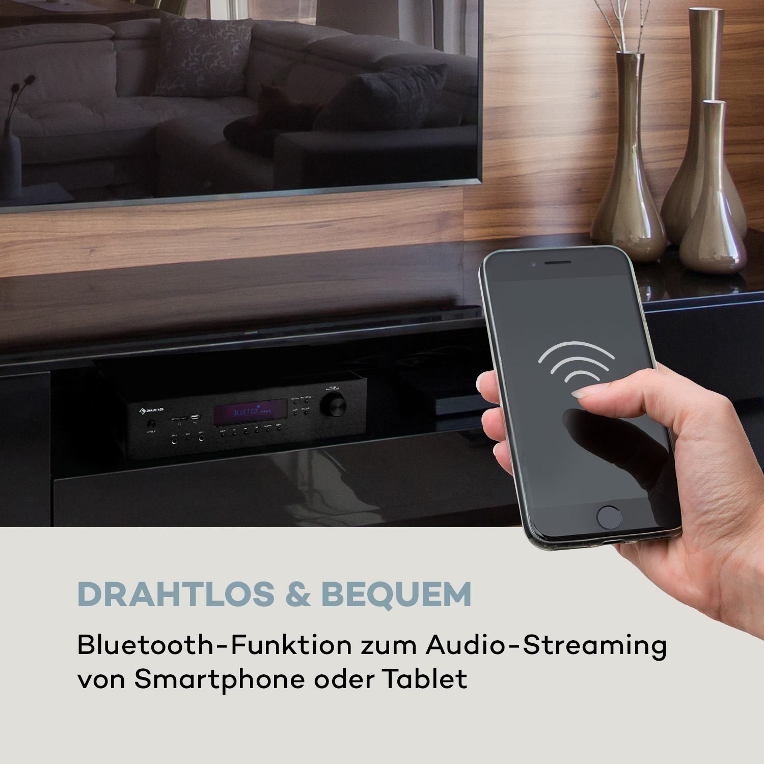 Hand hält Smartphone mit WLAN-Symbol vor einem Receiver und Fernseher.
