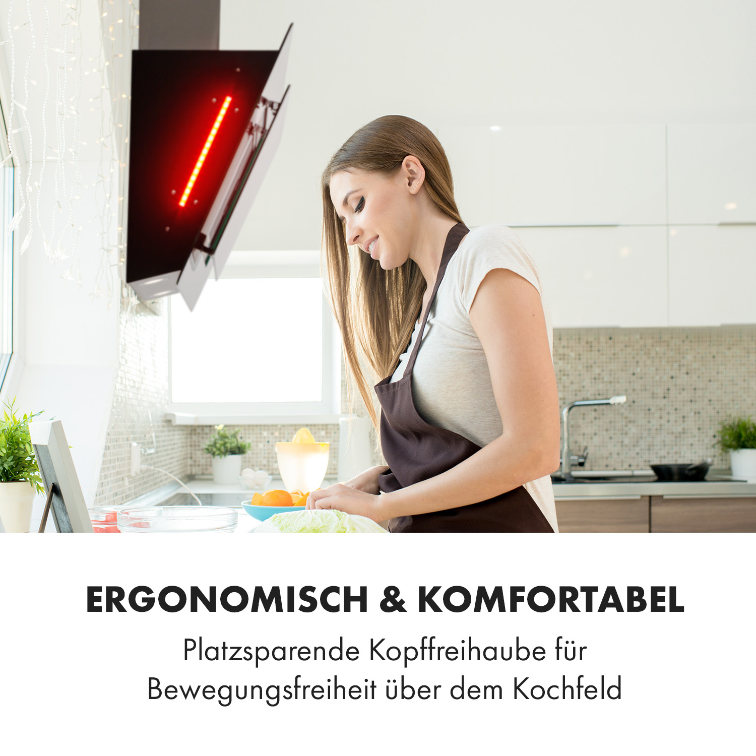 Donna cucina in una cucina moderna sotto una cappa aspirante con luce rossa.
