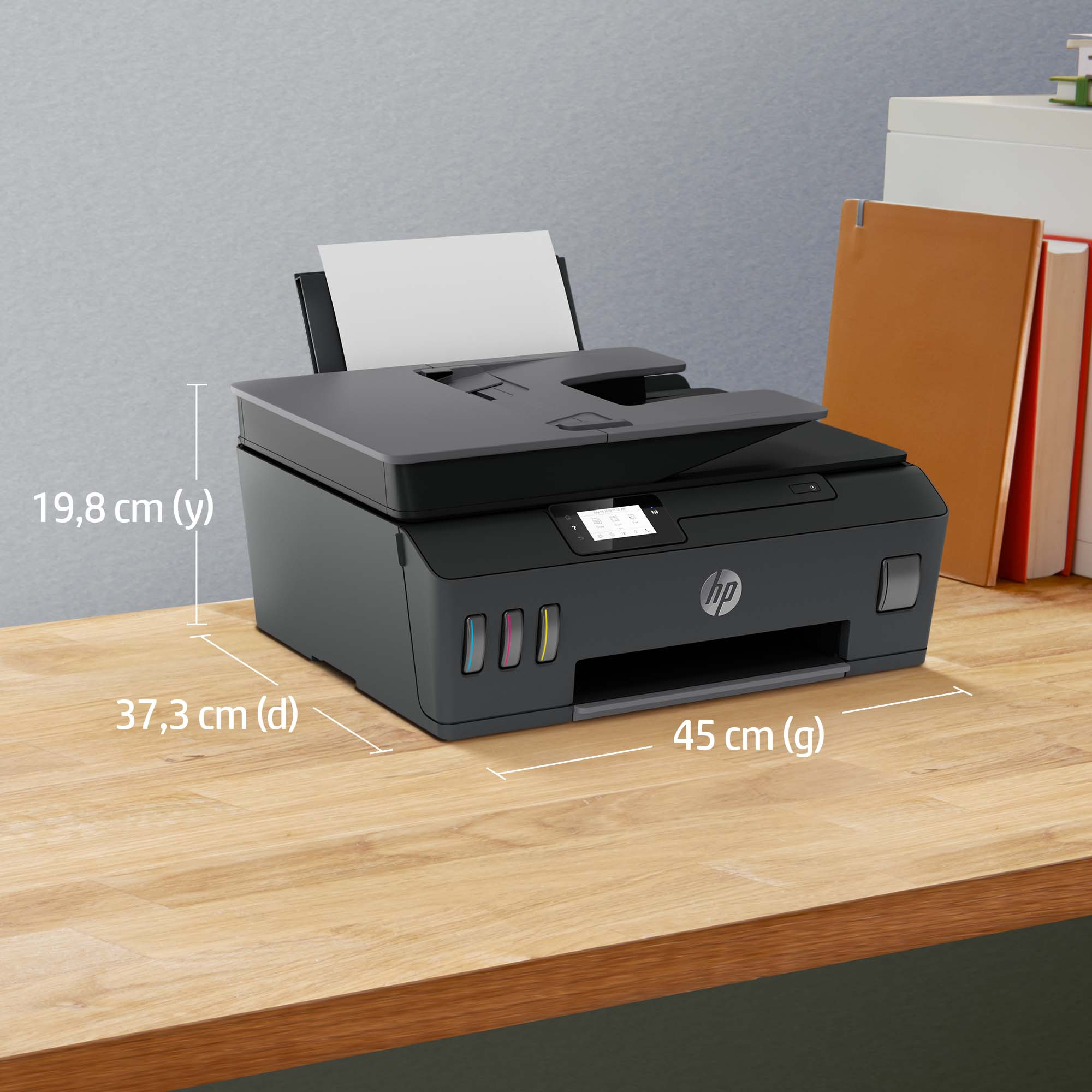 Ahşap bir masanın üzerinde mürekkep tankları olan siyah HP yazıcı.