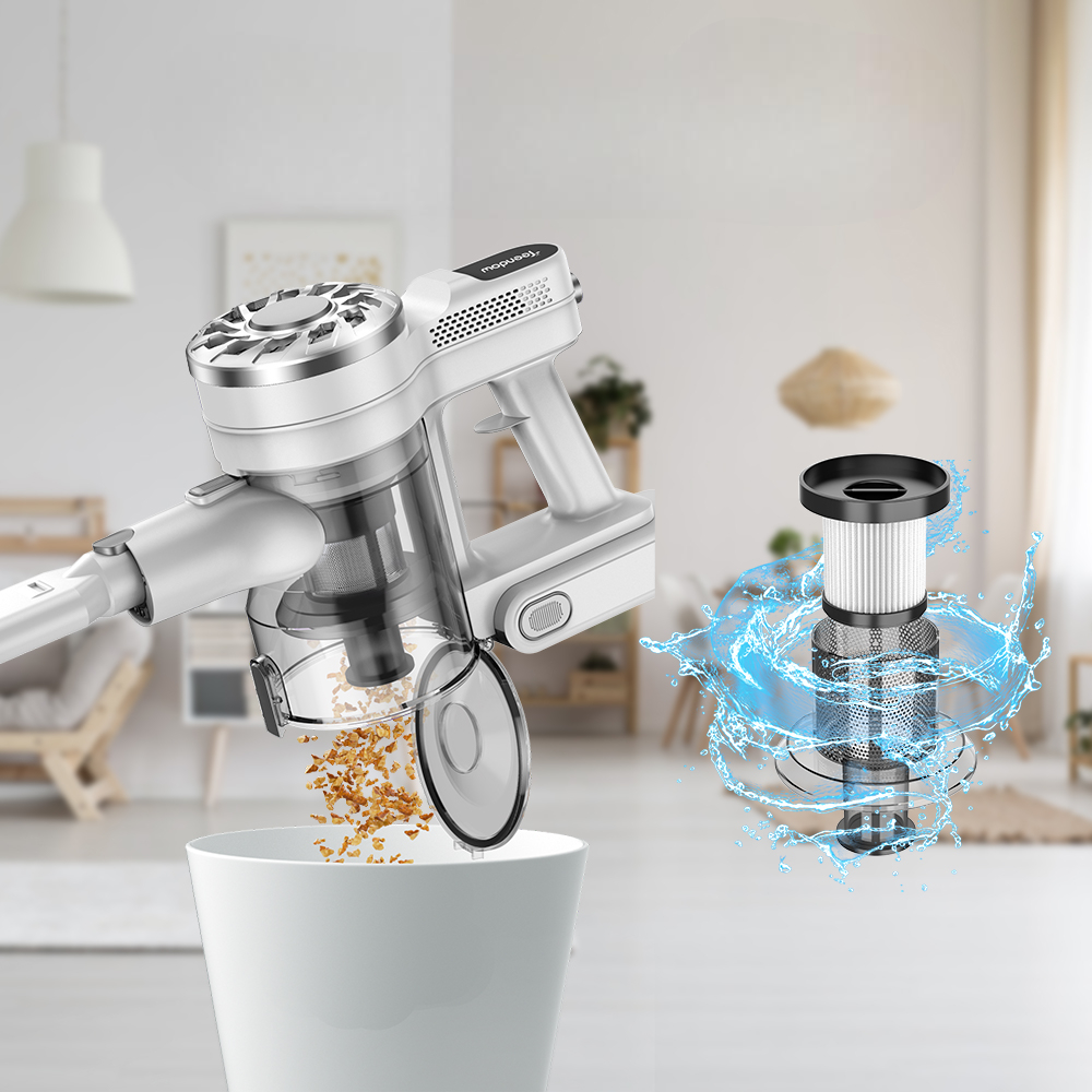 Ein weißer Handstaubsauger leert seinen Behälter in einen weißen Mülleimer. Ein Filter mit Wasser spritzt.