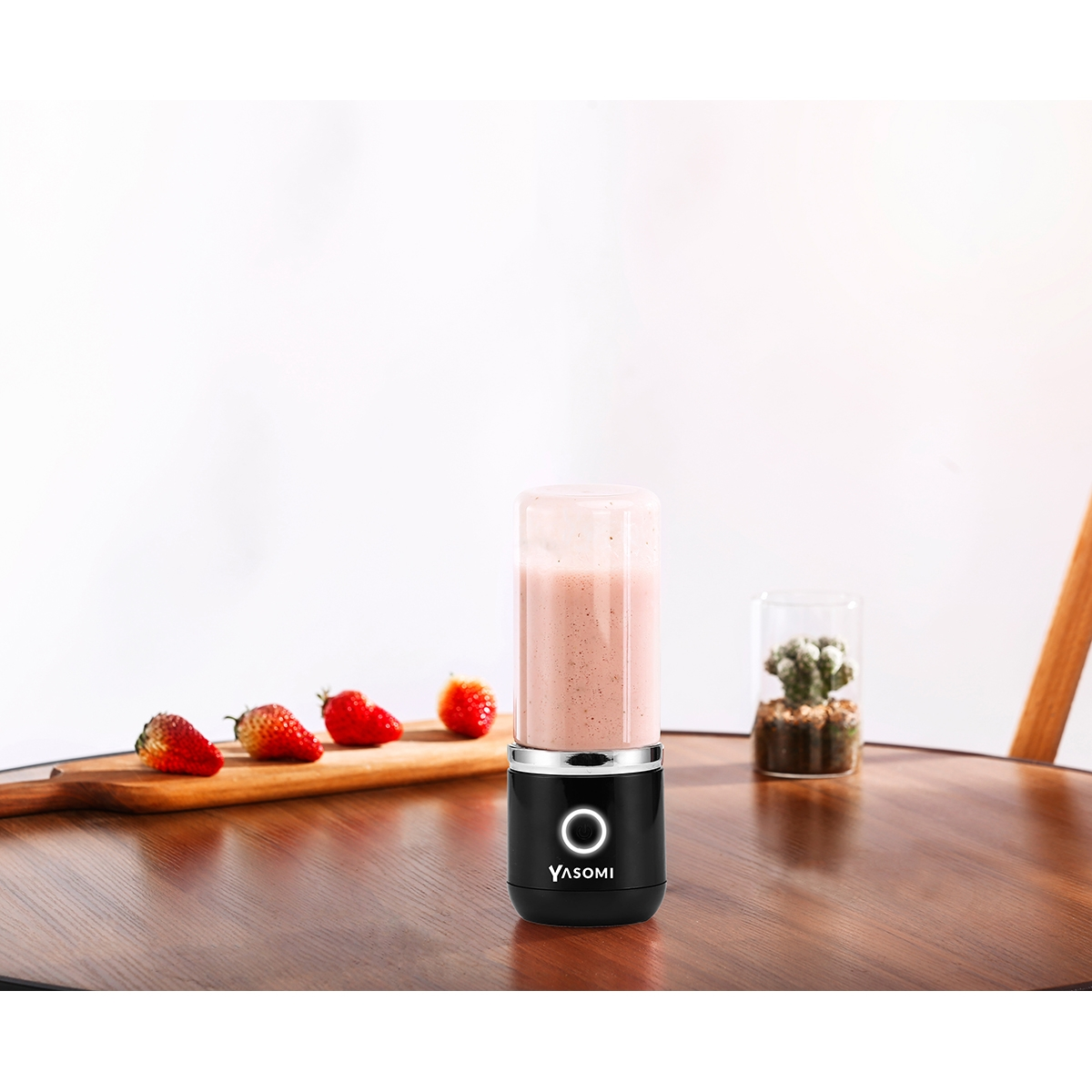 Çilek ve küçük bir kaktüs ile siyah taşınabilir blender.