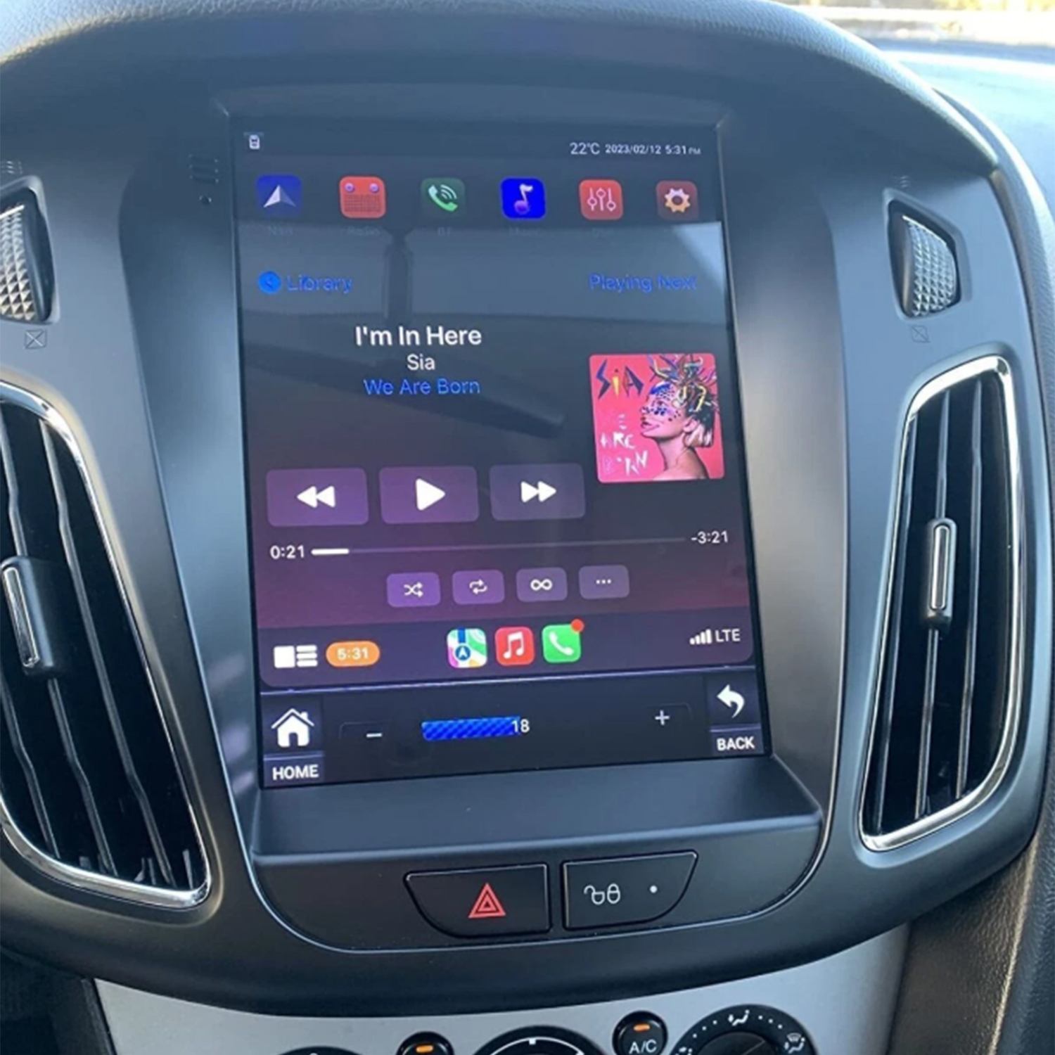 Schermo infotainment auto con riproduzione musicale, canzone di Sia.