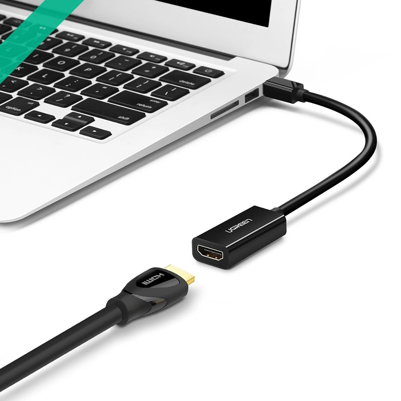 Czarny adapter HDMI łączy się z portem USB-C laptopa za pomocą kabla.