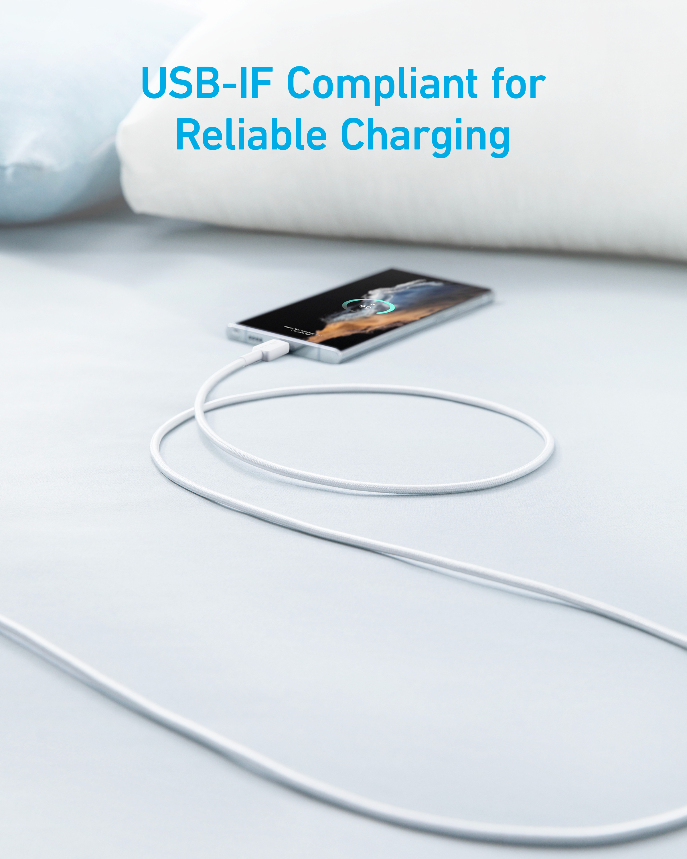 Un cavo USB bianco carica uno smartphone su un letto.