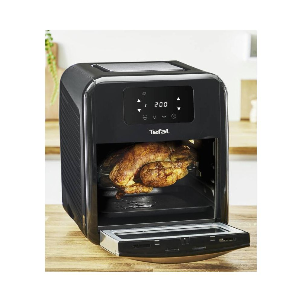 Złocisty kurczak piecze się w czarnej frytkownicy beztłuszczowej Tefal.