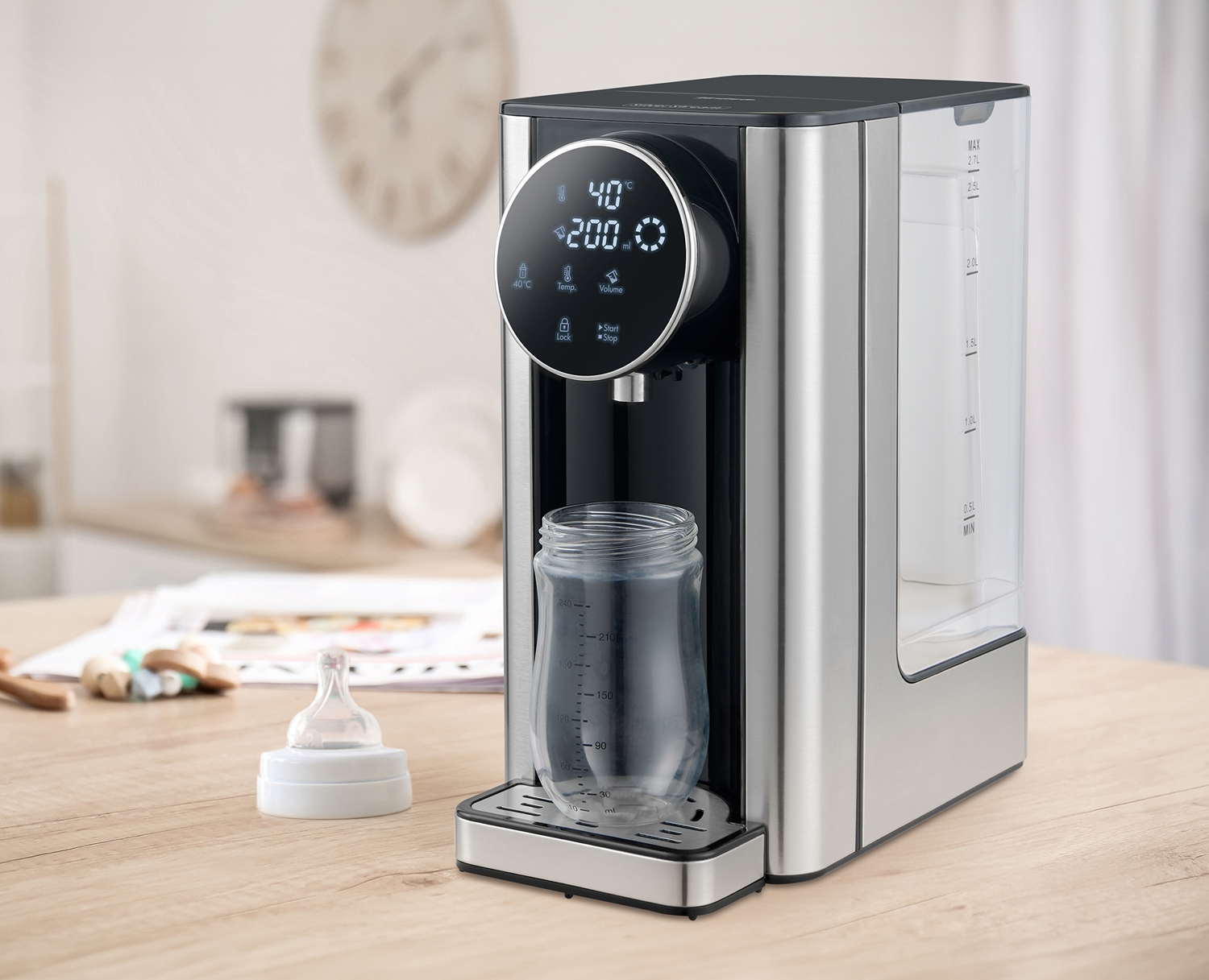 Ein Wasserspender mit digitalem Display, Babyflasche und Schnuller auf einem Holztisch.