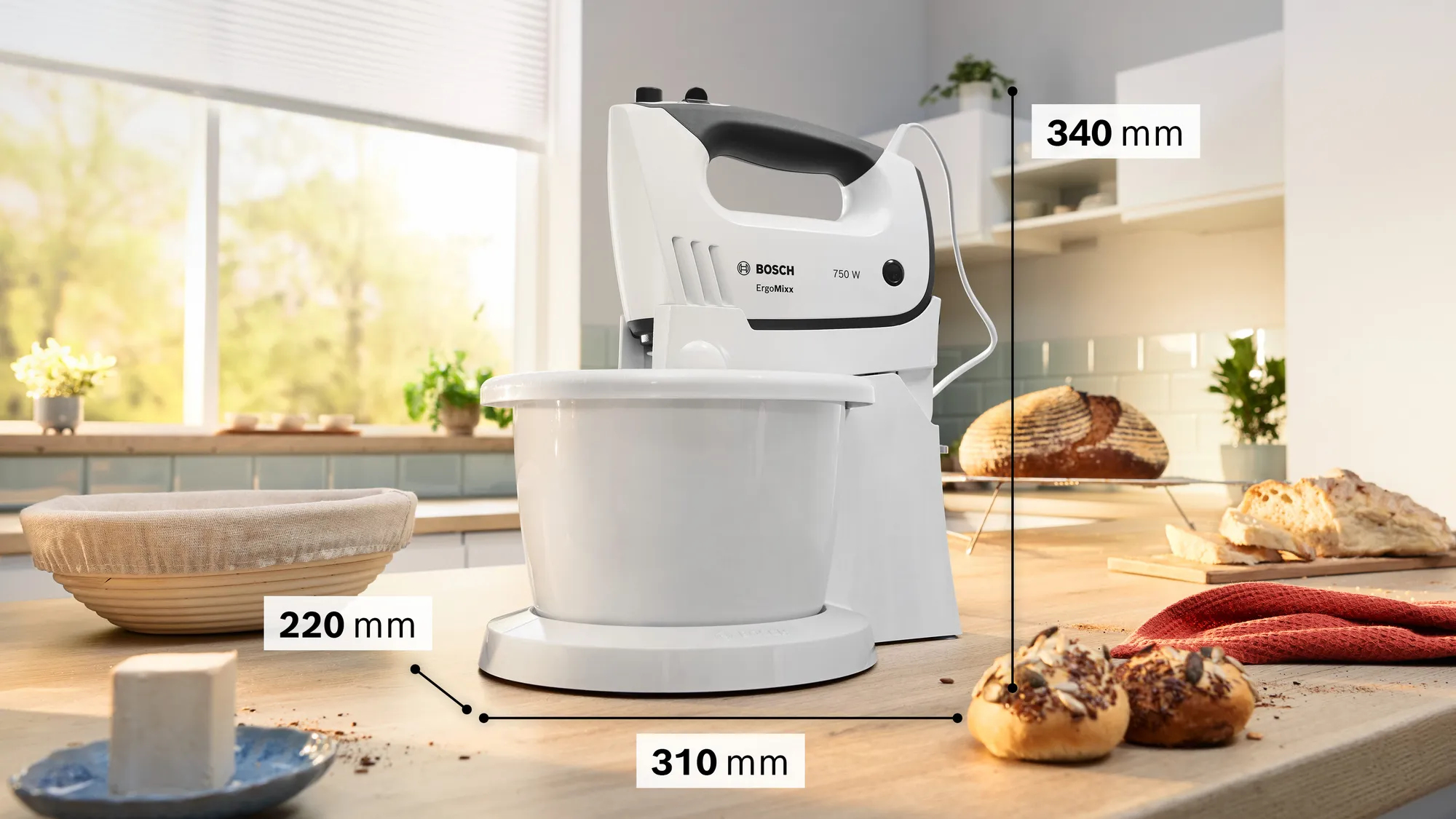 Ein weißer Bosch Handmixer mit Schüssel steht auf einem Holztresen.