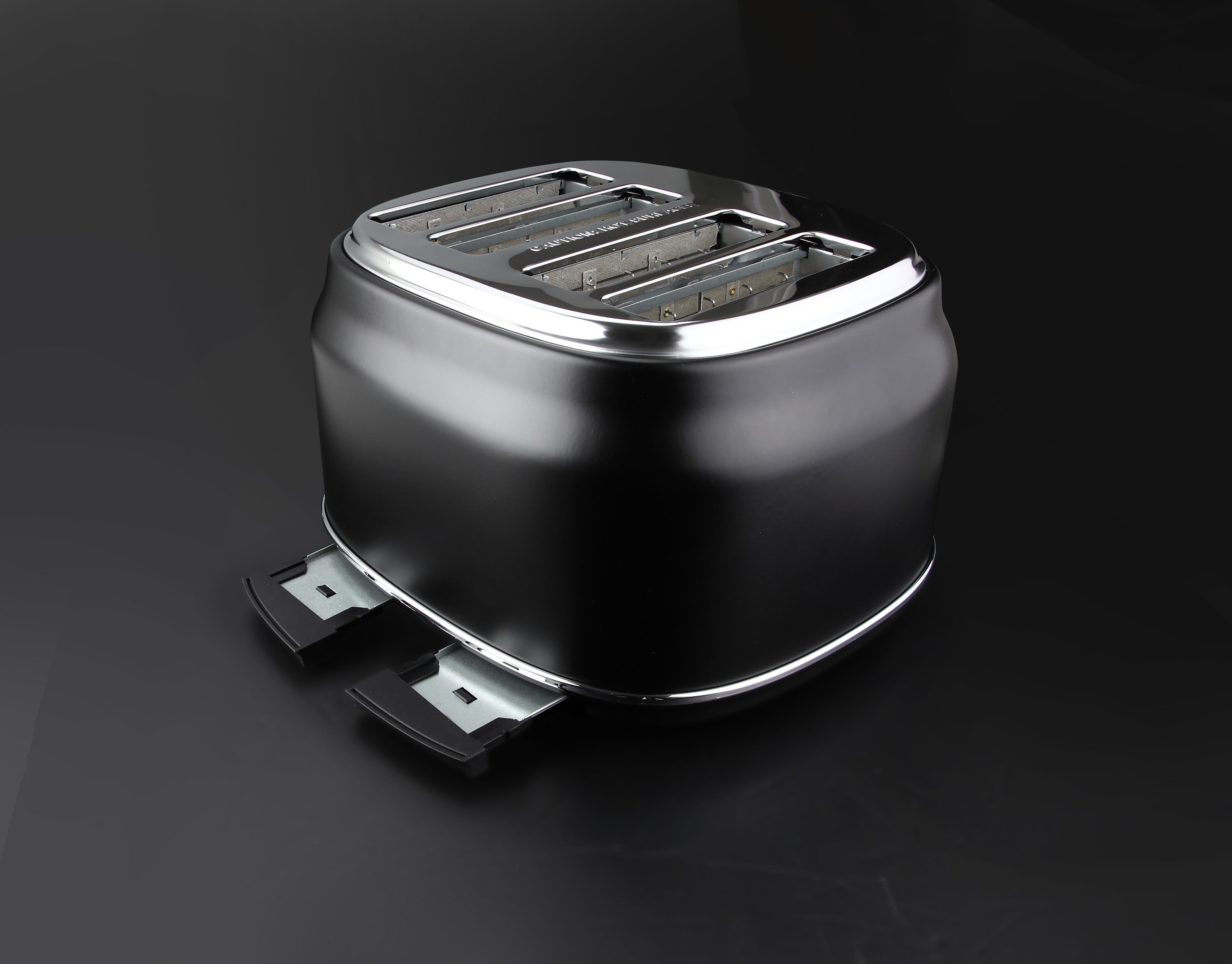 Ein schwarzer Toaster mit Chromrand steht auf schwarzem Untergrund.
