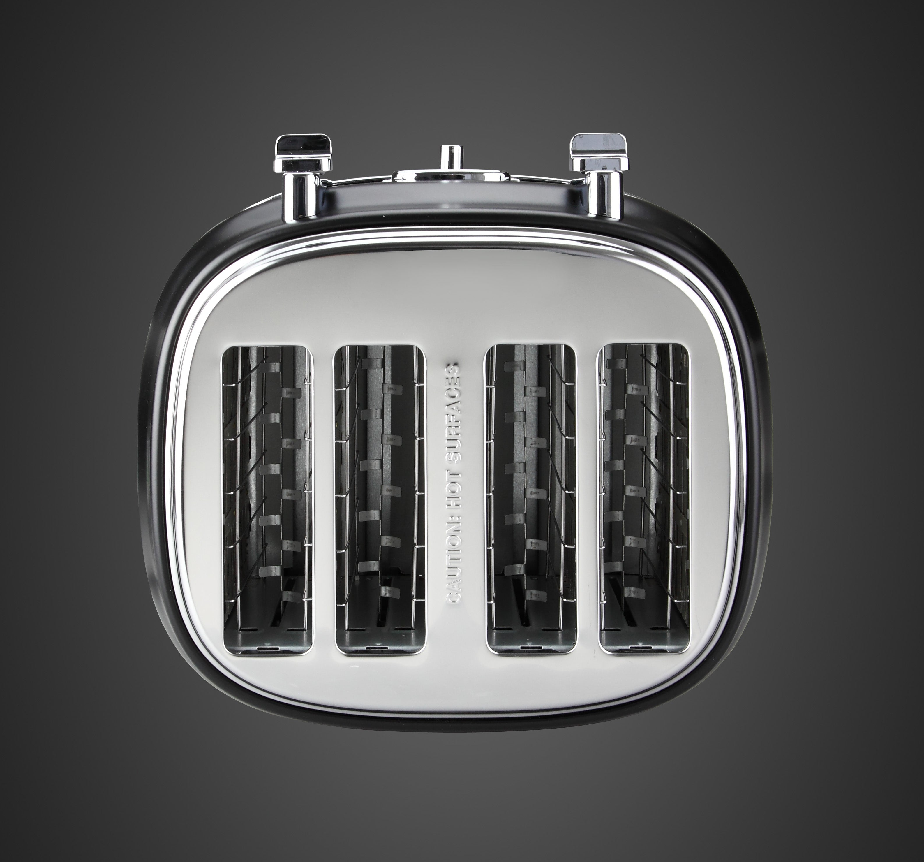 Ein silberner Toaster mit vier Schlitzen auf dunklem Hintergrund.