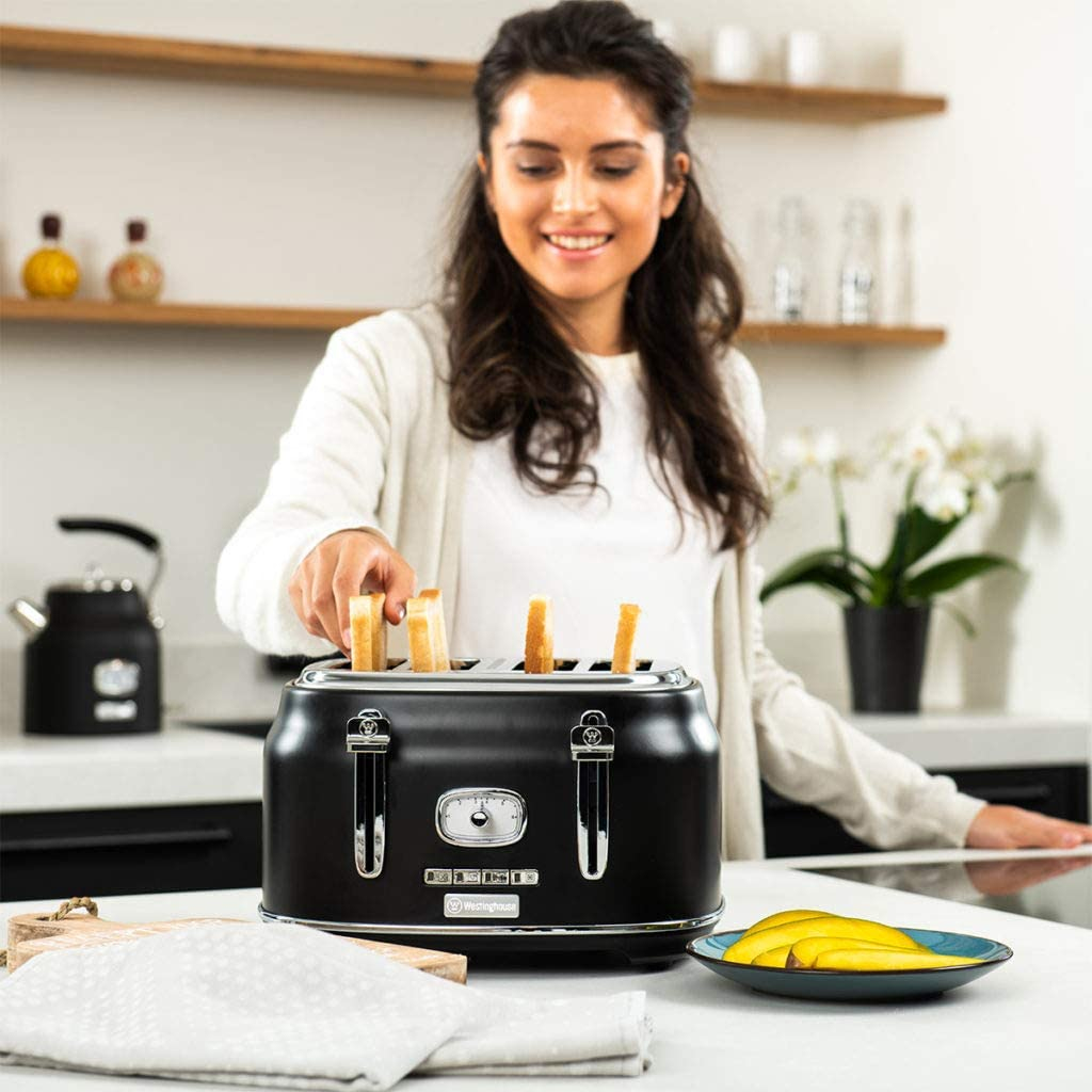 Frau legt Toastbrote in schwarzen Toaster, daneben liegen Bananenscheiben.