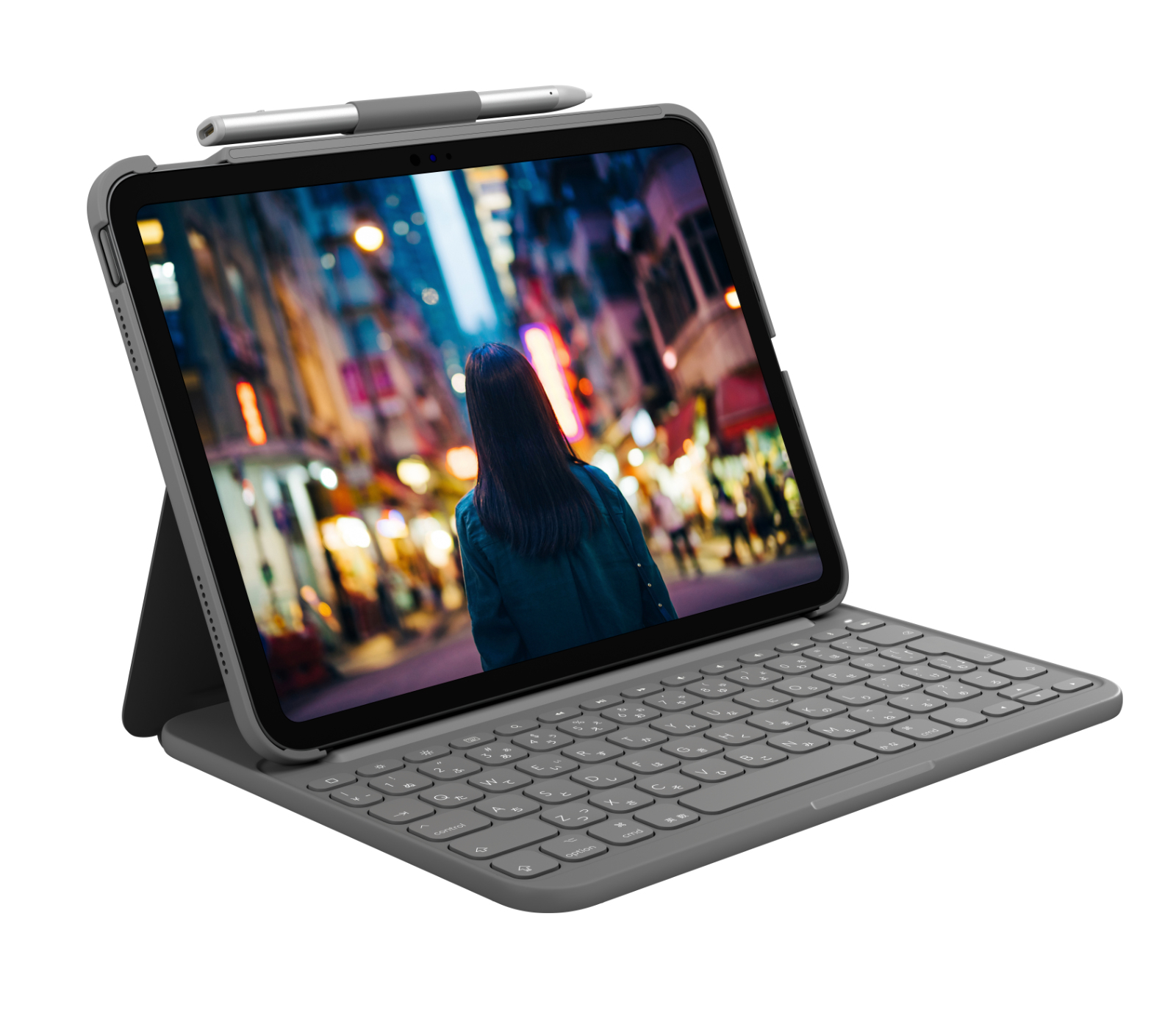 Tablet z klawiaturą i rysikiem, wyświetlający kobietę na oświetlonej ulicy.