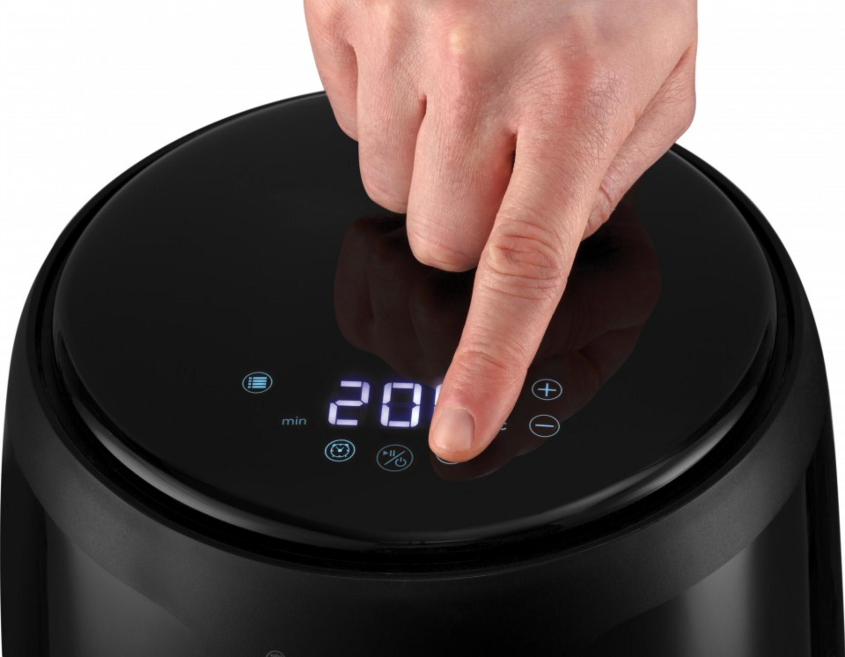 Un dito preme il display di un apparecchio nero che mostra '20 min'.