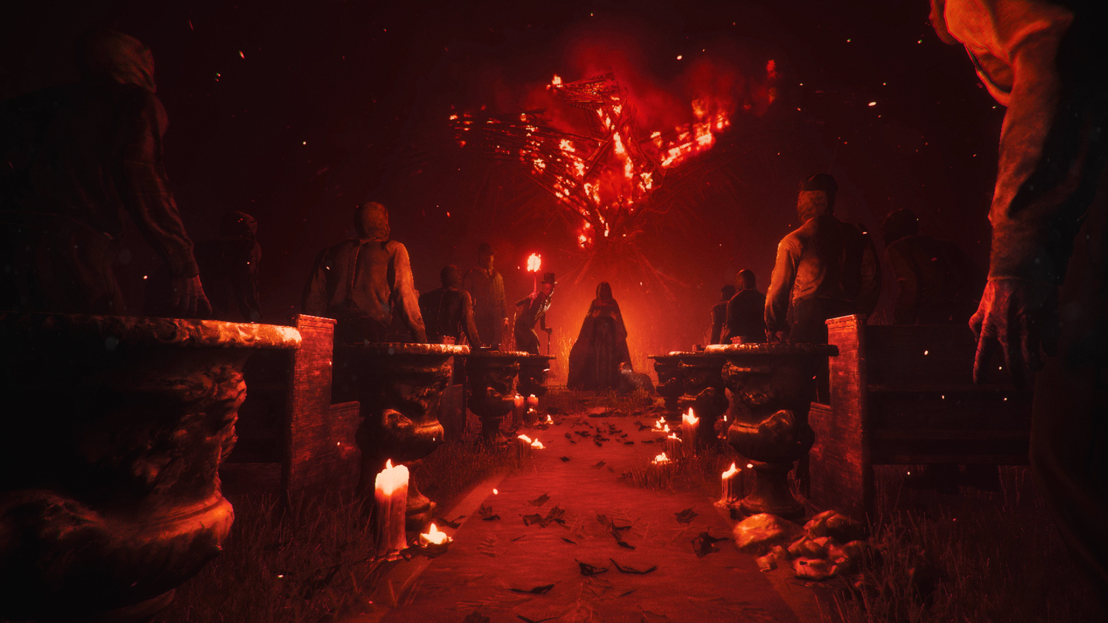 Diverse figure si ergono davanti a una struttura in fiamme, illuminate da candele.