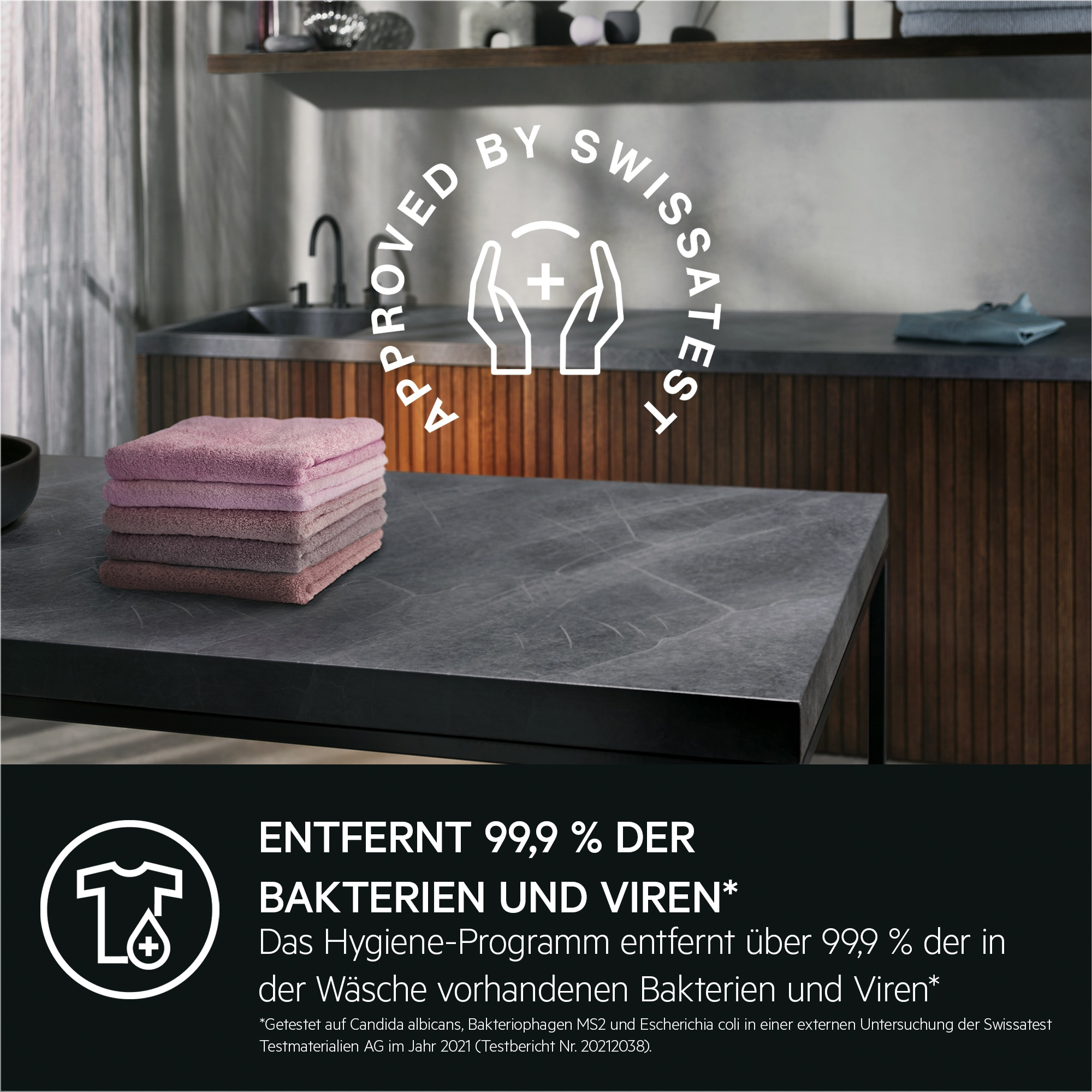 Ein Stapel rosafarbener Handtücher auf einem Tisch vor einem Waschbecken.