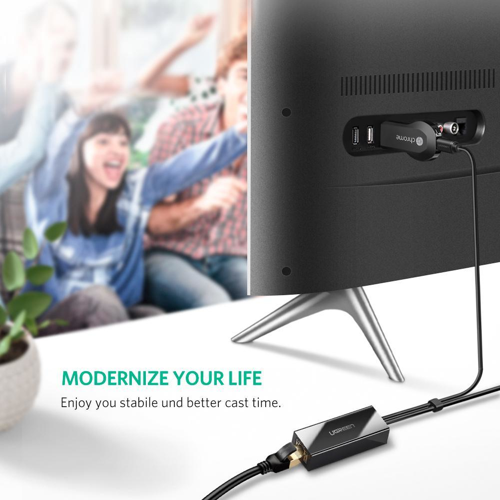 Chromecast an TV, Leute jubeln im Hintergrund. HDMI-Adapter am Kabel.