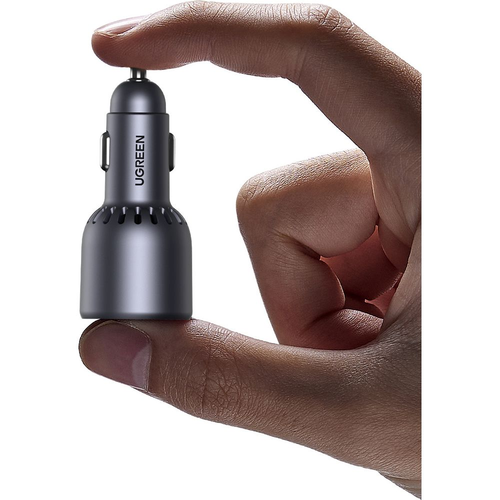 Ładowarka UGREEN w dłoni, mała i czarna z widocznymi szczelinami wentylacyjnymi.