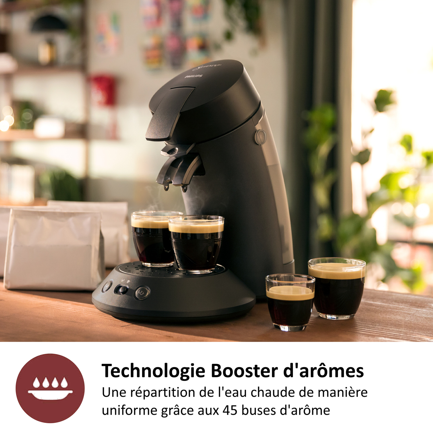 Czarny ekspres do kawy parzy kawę do trzech szklanek. Dwie białe paczki po lewej.