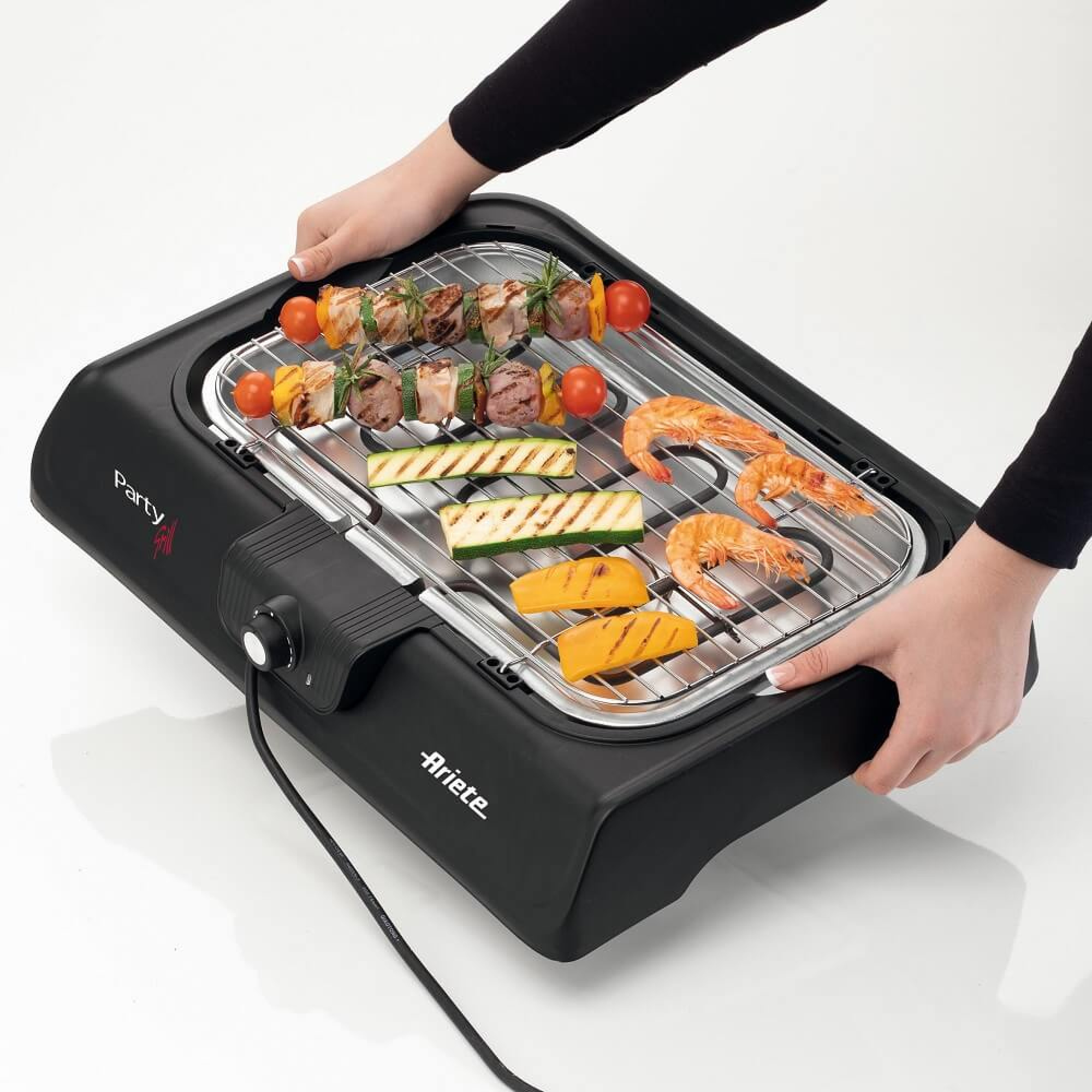 Ein schwarzer Elektrogrill mit Speisen: Spieße, Garnelen, Zucchini und Käse.