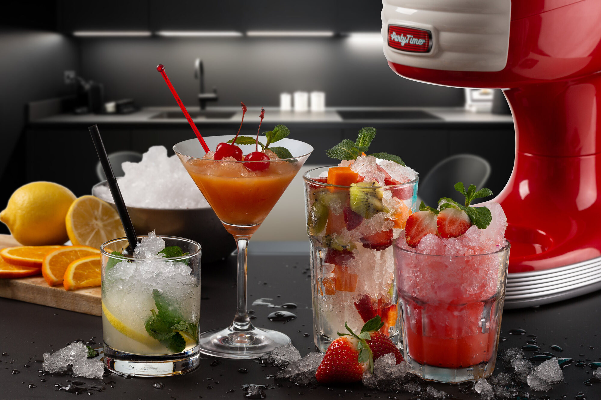Cocktail freschi con frutta e ghiaccio davanti a un bancone da cucina e una gelatiera.
