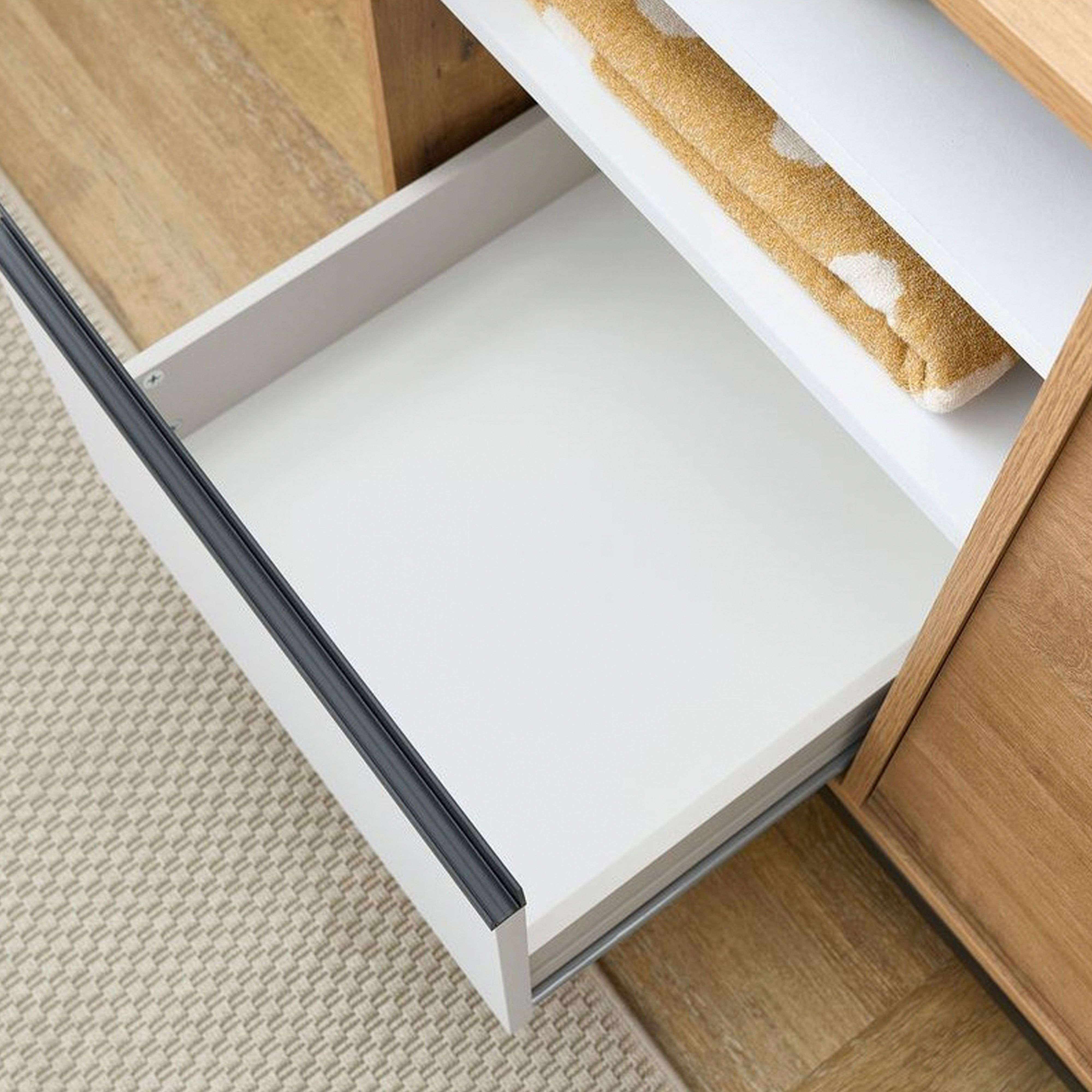 Un cajón abierto en un mueble, con una toalla amarilla dentro.