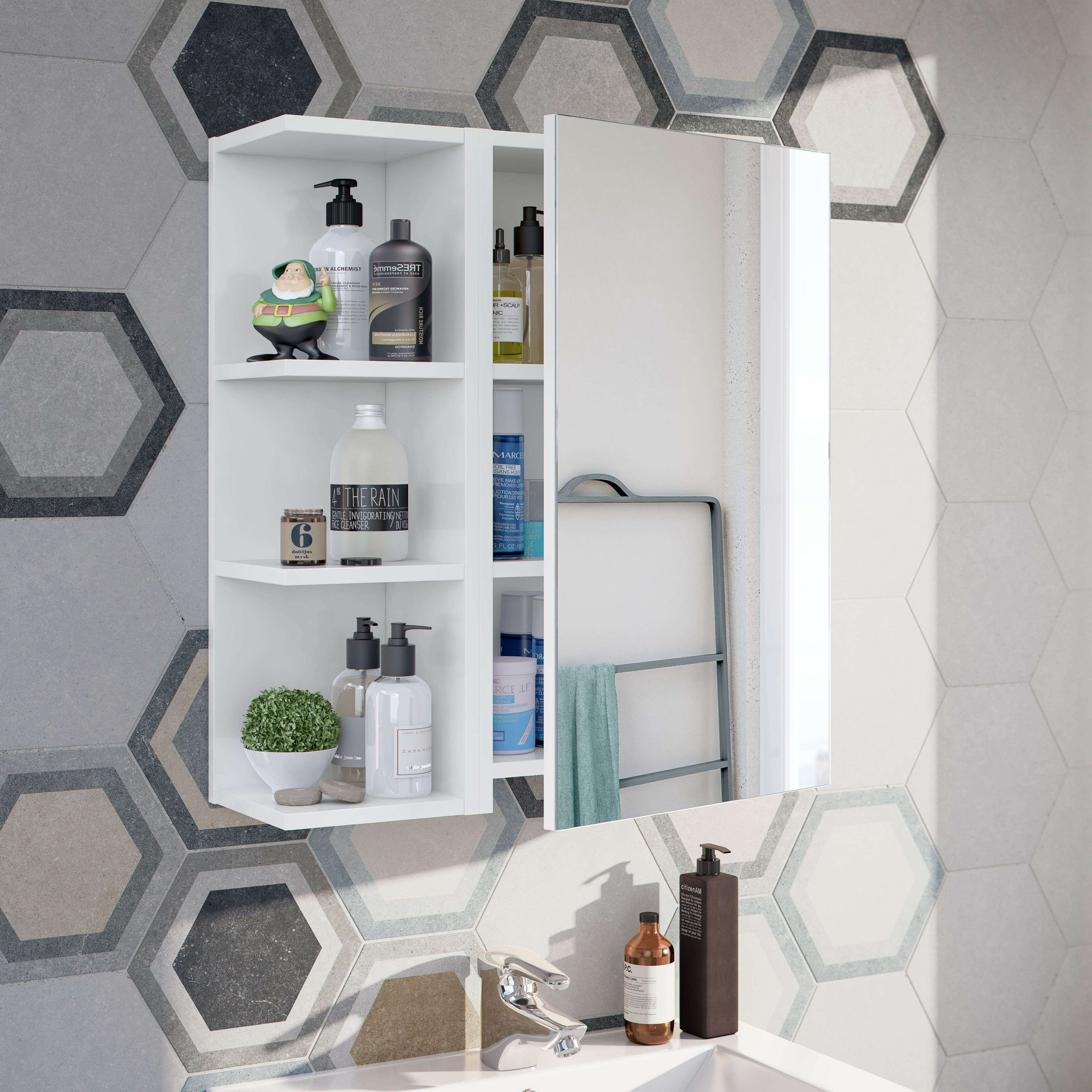 Un mueble de baño blanco con espejo, lleno de botellas y una figura de gnomo verde.