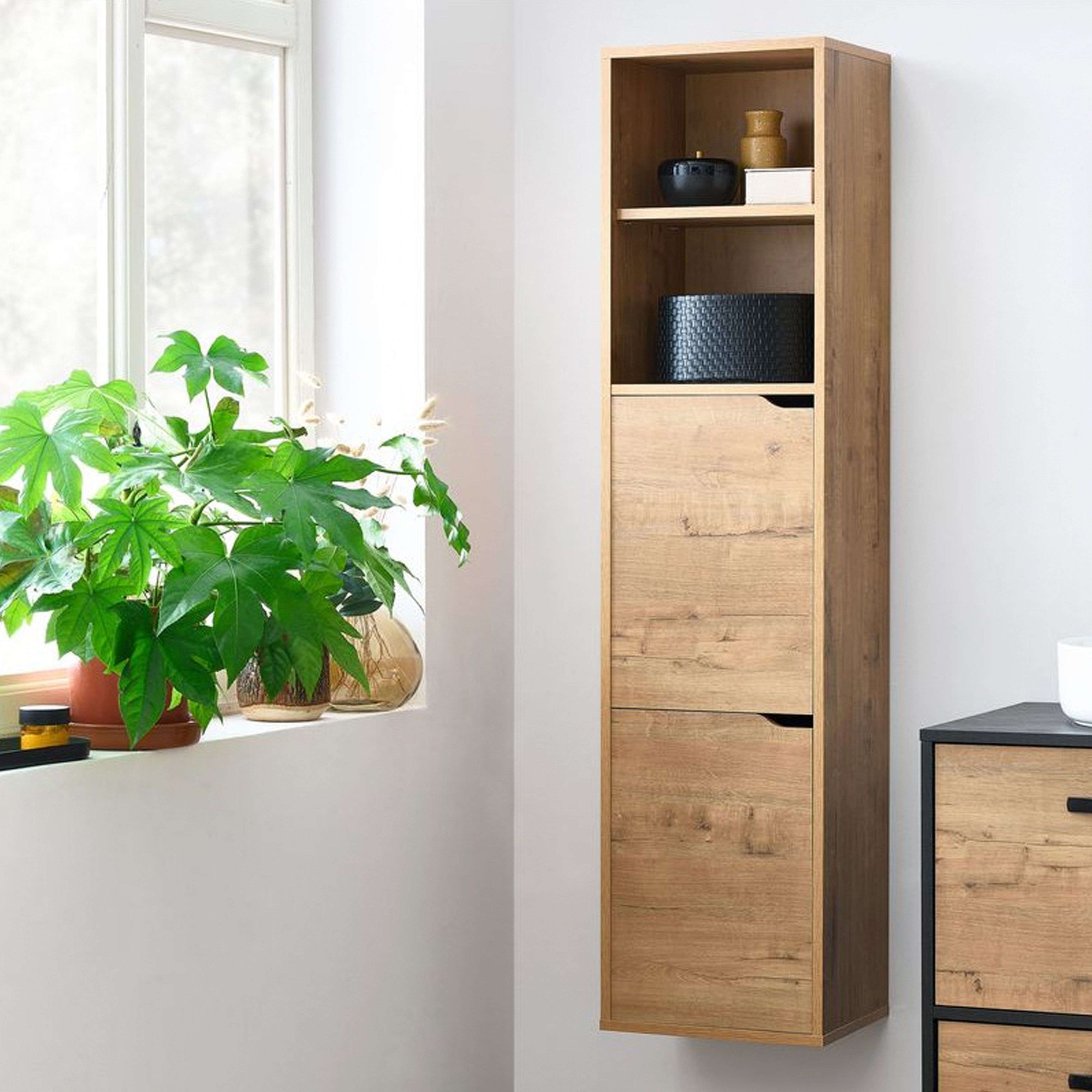 Un mueble estrecho de madera junto a una ventana con una planta verde.
