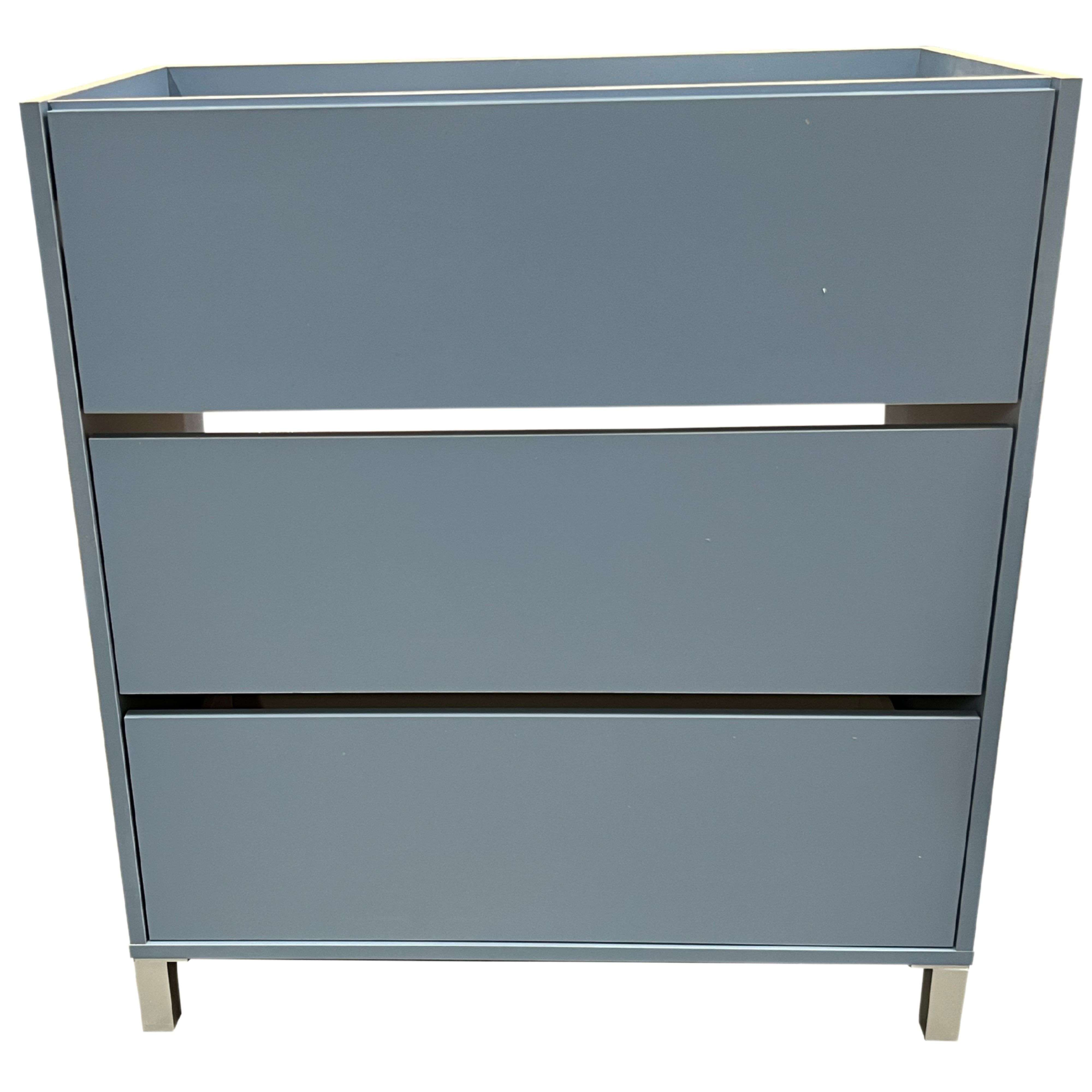 Gabinete gris con tres cajones y patas metálicas.