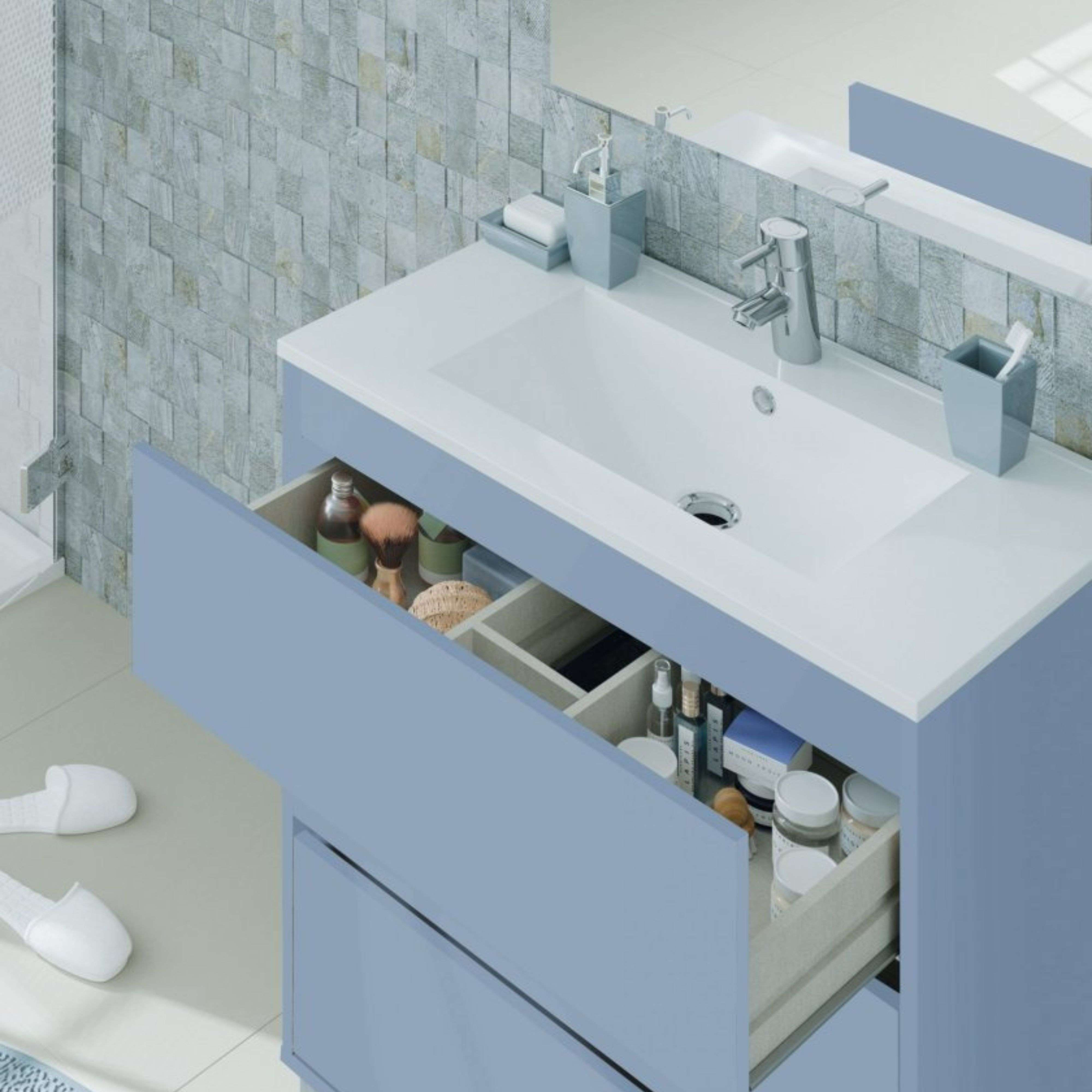 Un tocador de baño azul claro con un cajón abierto lleno de artículos de tocador.