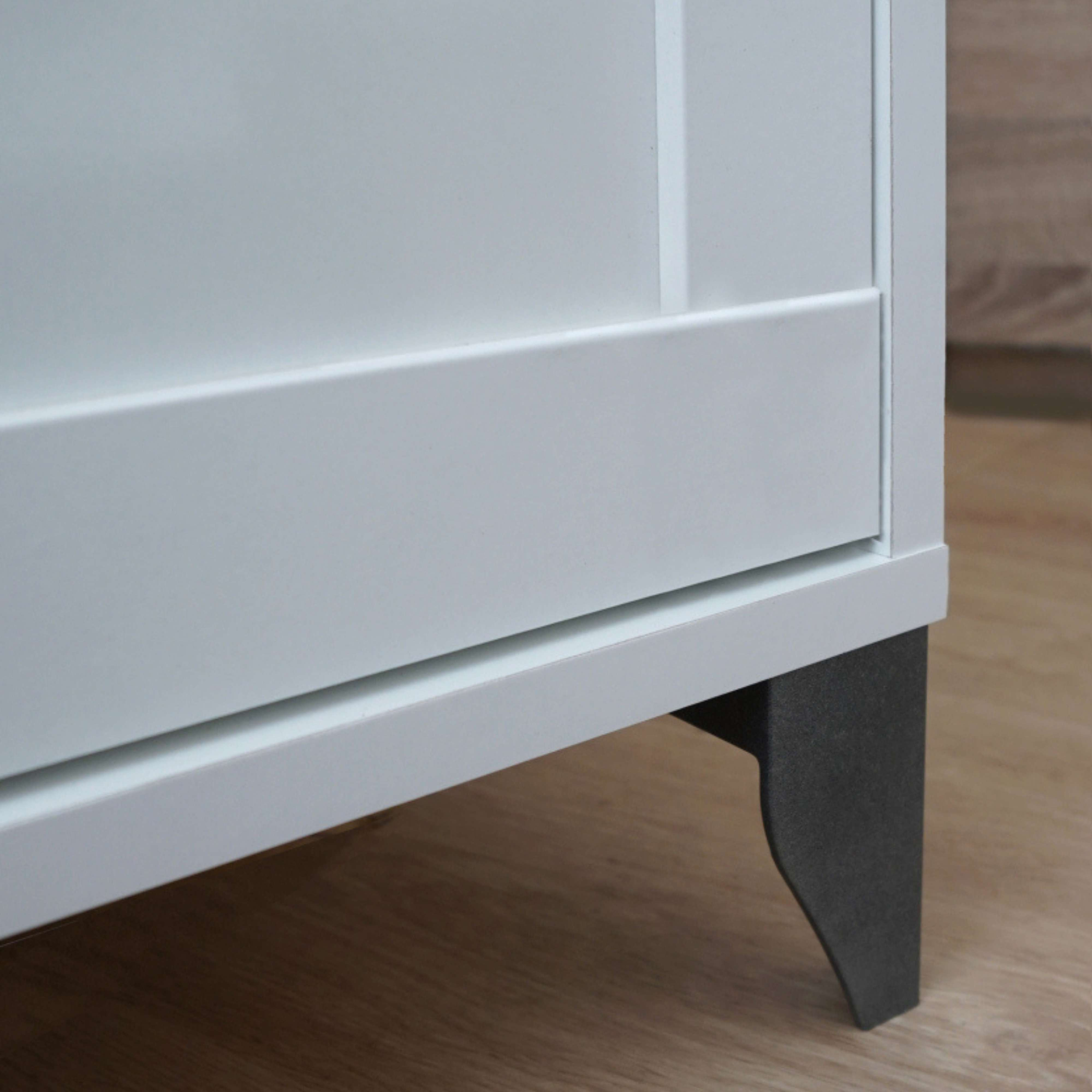 Un mueble blanco con base oscura sobre suelo de madera.