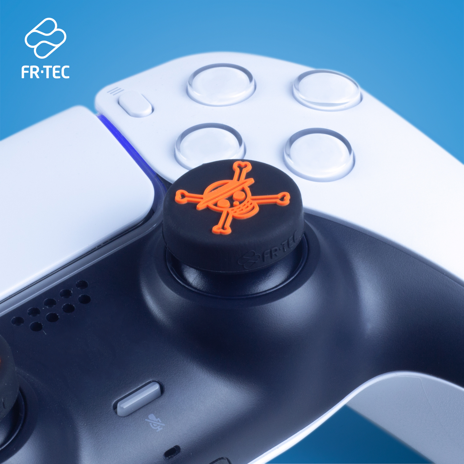 Un controller bianco e nero con un pollice a teschio arancione.