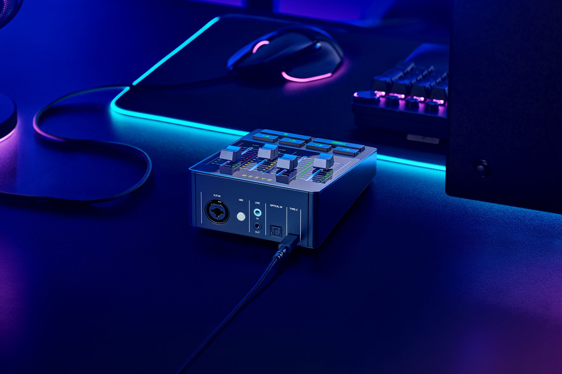 Ein schwarzer Audio-Mixer mit Reglern und Anschlüssen, beleuchtet von blauem und lila Licht.