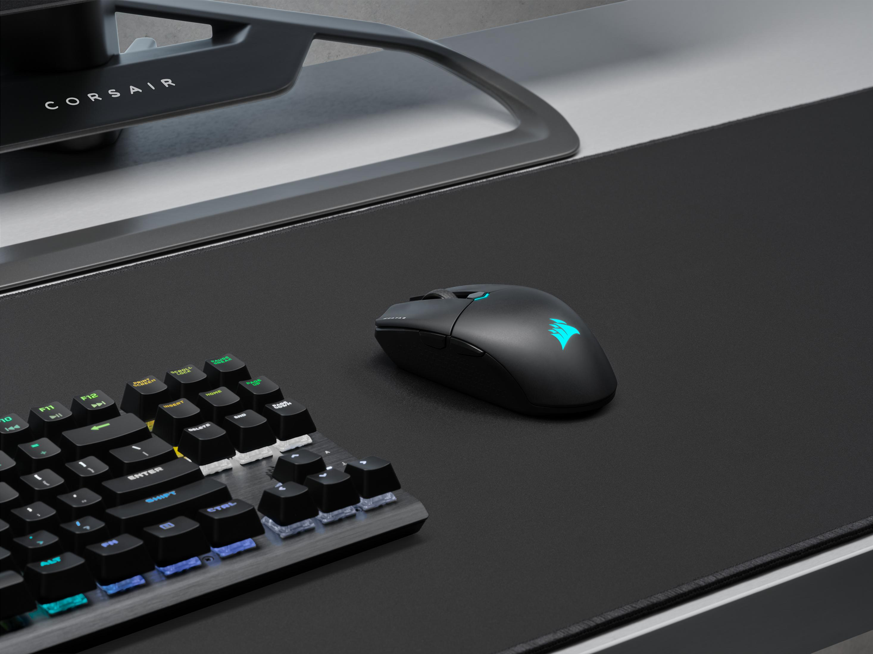 Zwarte muis en toetsenbord met RGB-verlichting op een zwarte mat.