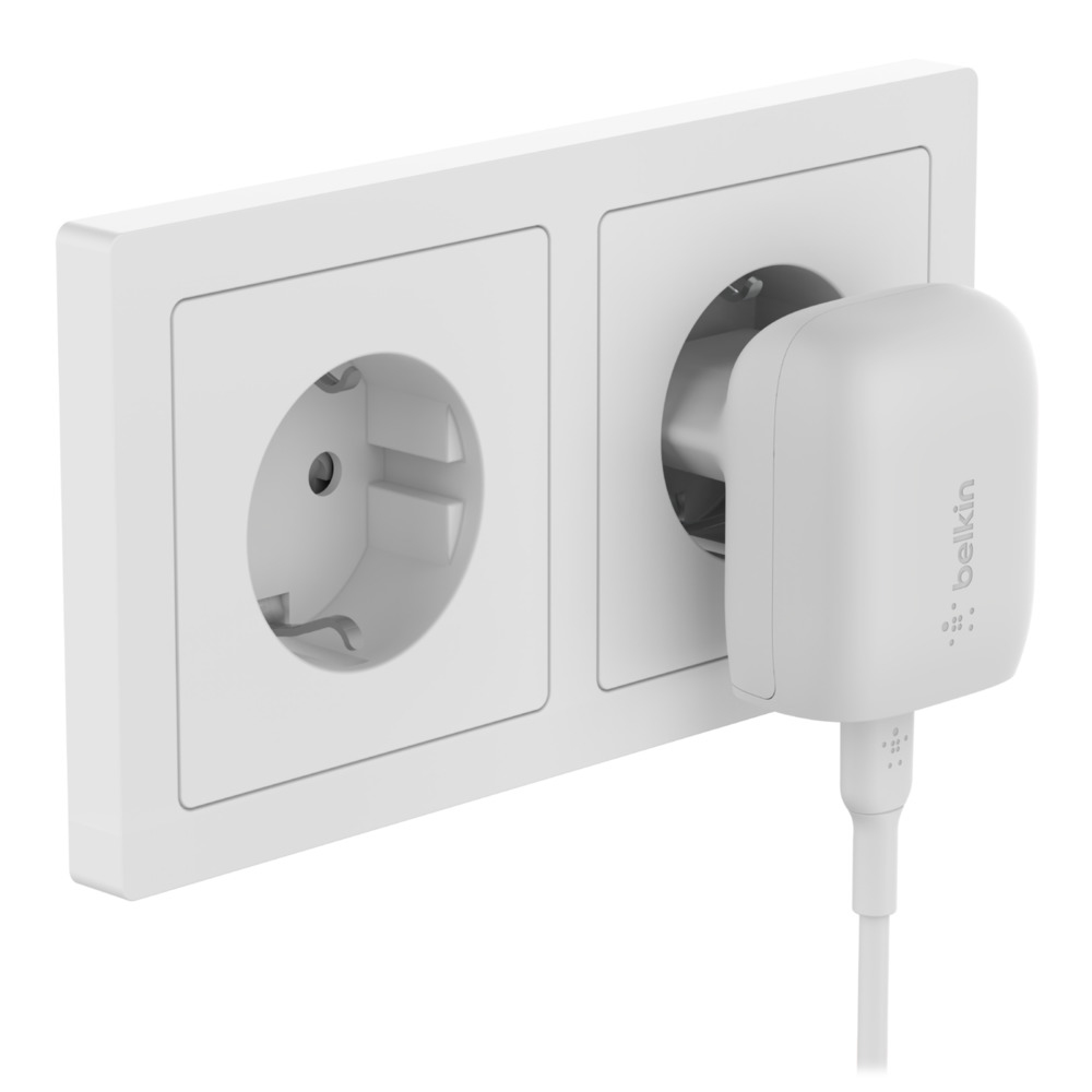 Un adattatore Belkin bianco è inserito in una presa a muro doppia bianca.