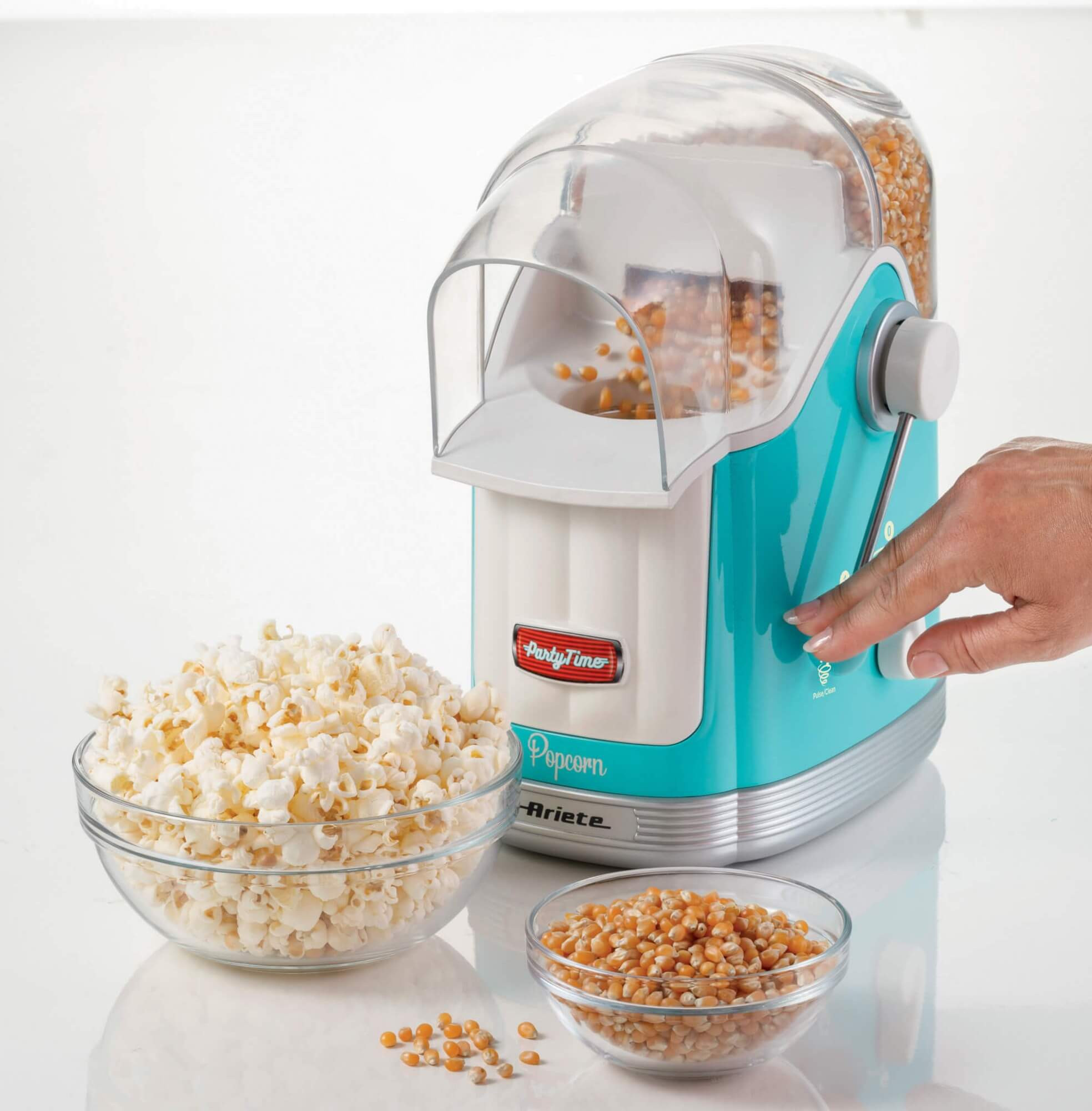 Macchina per popcorn turchese con una ciotola di popcorn e chicchi di mais.