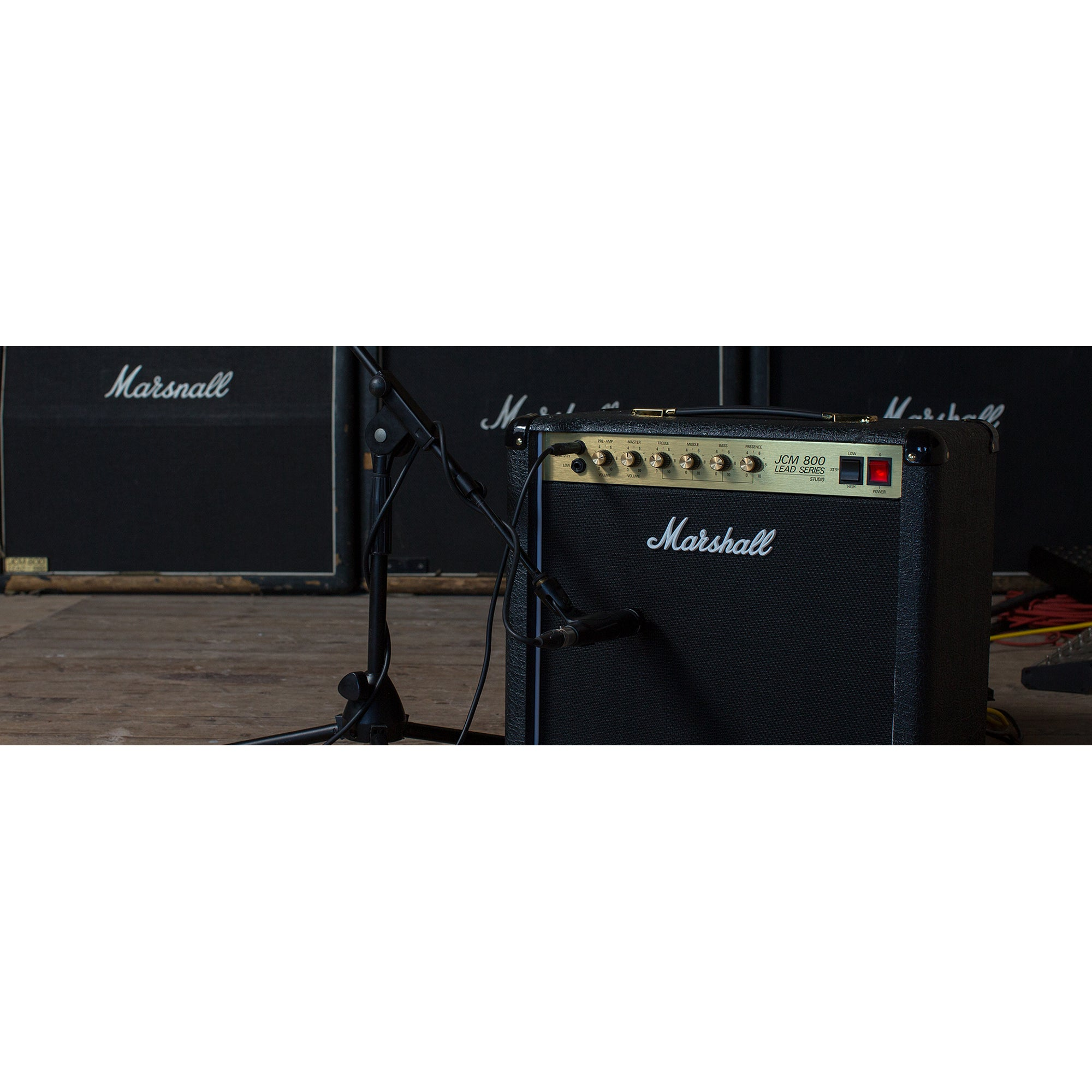 Een zwarte Marshall JCM 800 gitaarversterker met gouden knoppen en rode lampjes.