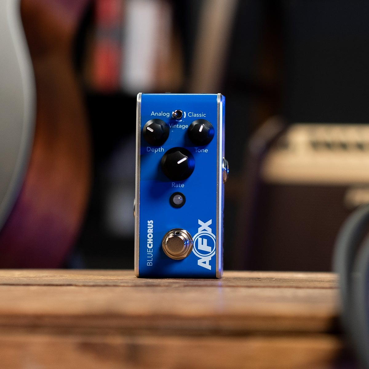 A blue guitar effects pedal with three knobs and a footswitch.