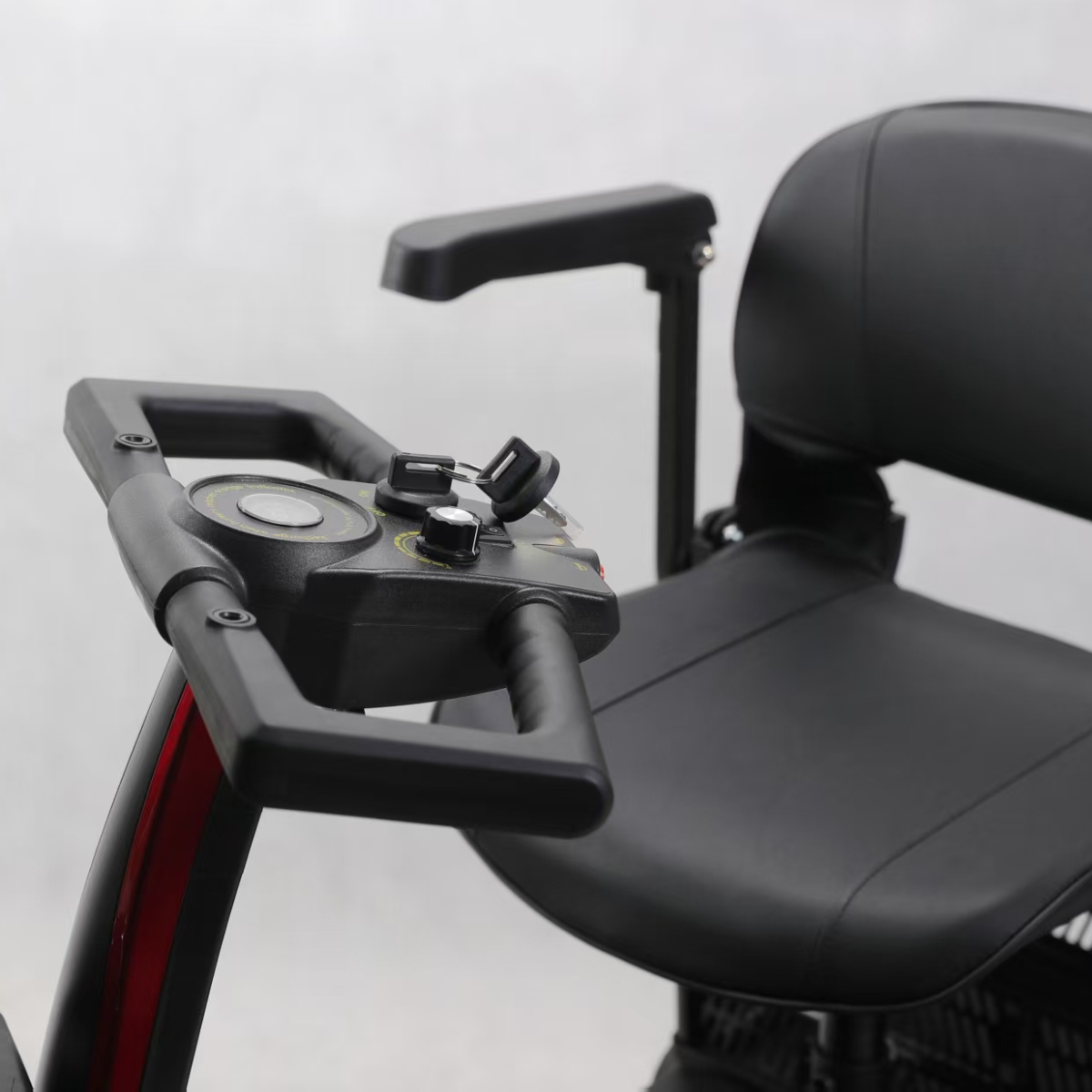 Część czarnego skutera inwalidzkiego z kierownicą i siedzeniem.