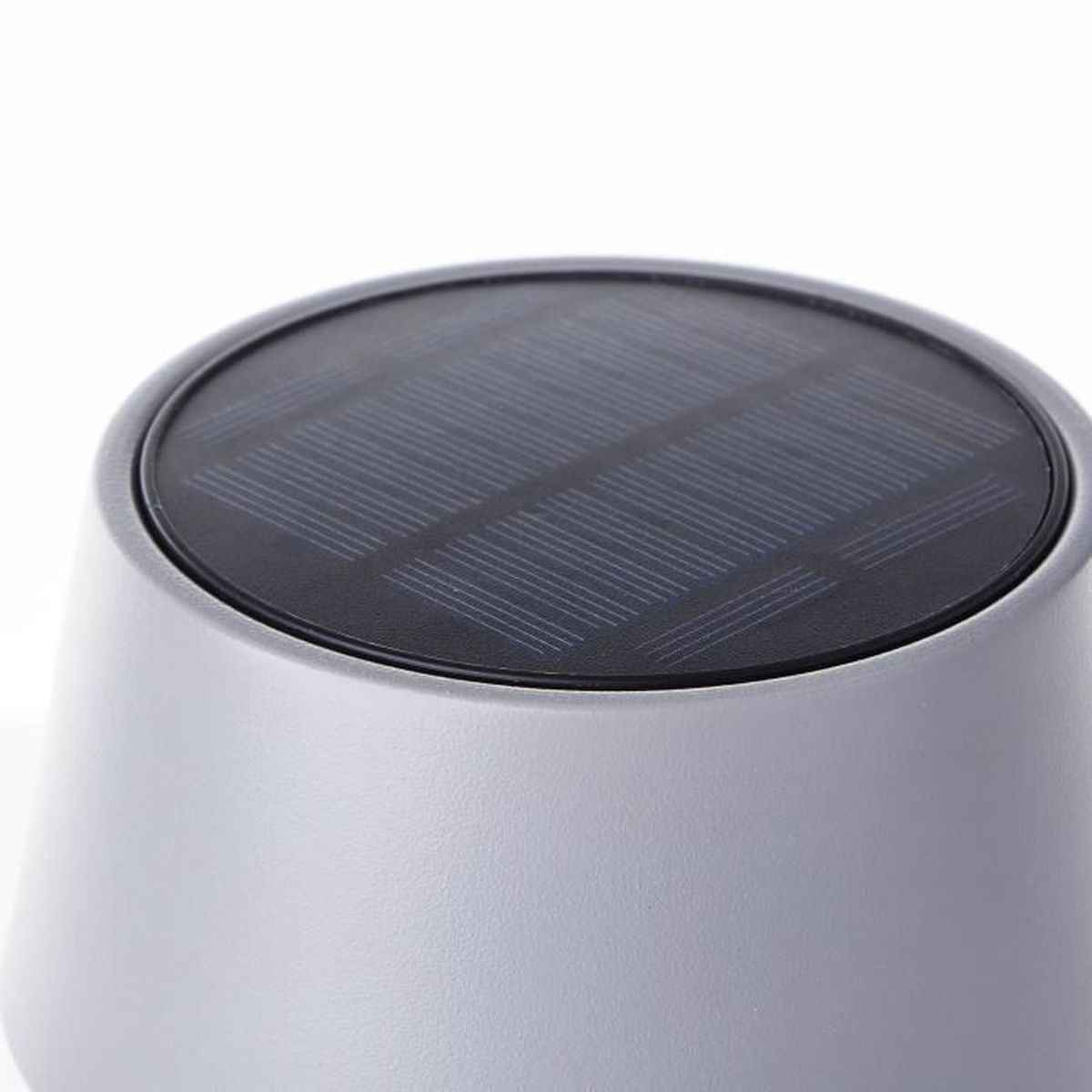 Nahaufnahme eines grauen Solarlichts mit sichtbarem Panel.