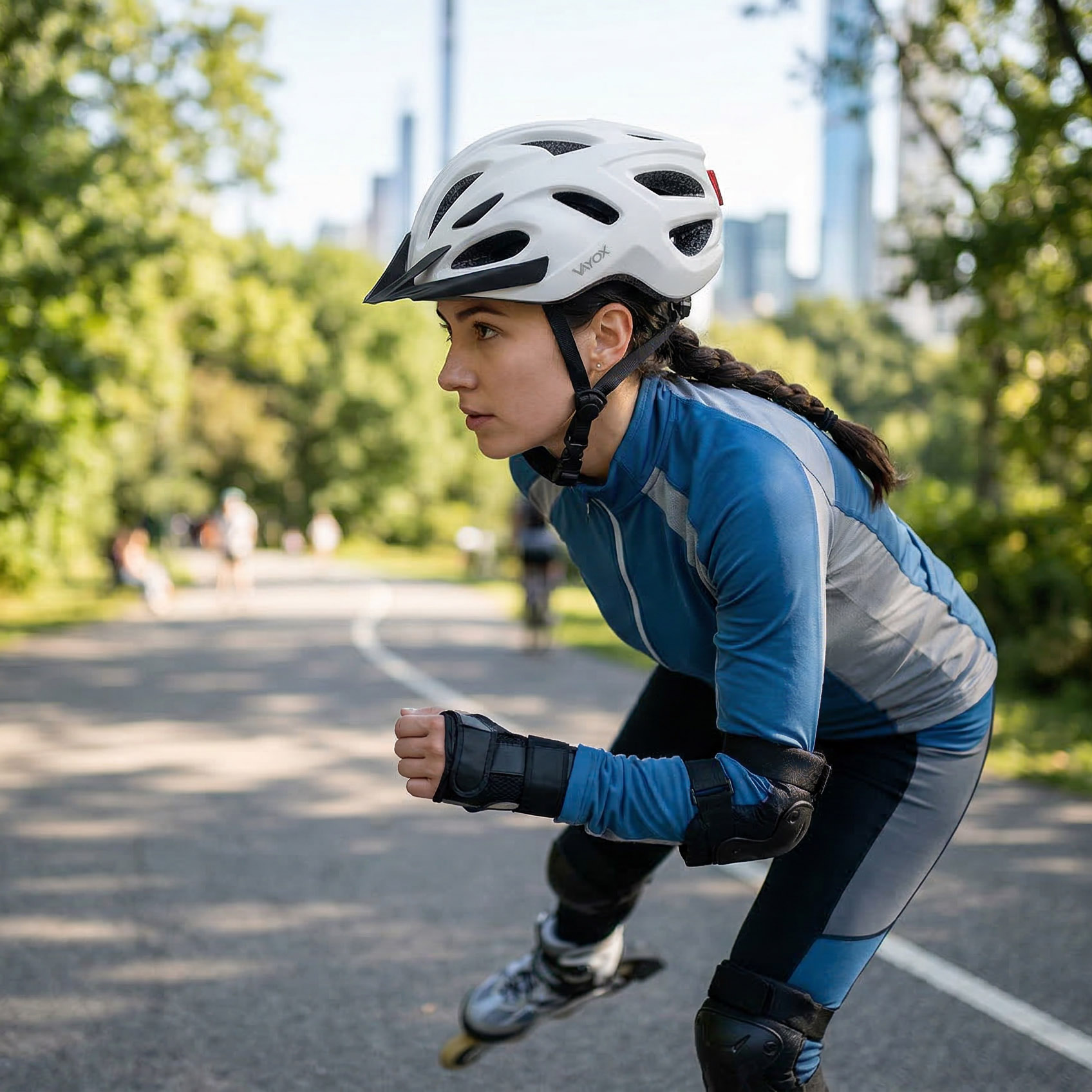 Kobieta w sprzęcie ochronnym jeździ na rolkach po asfaltowej ścieżce.