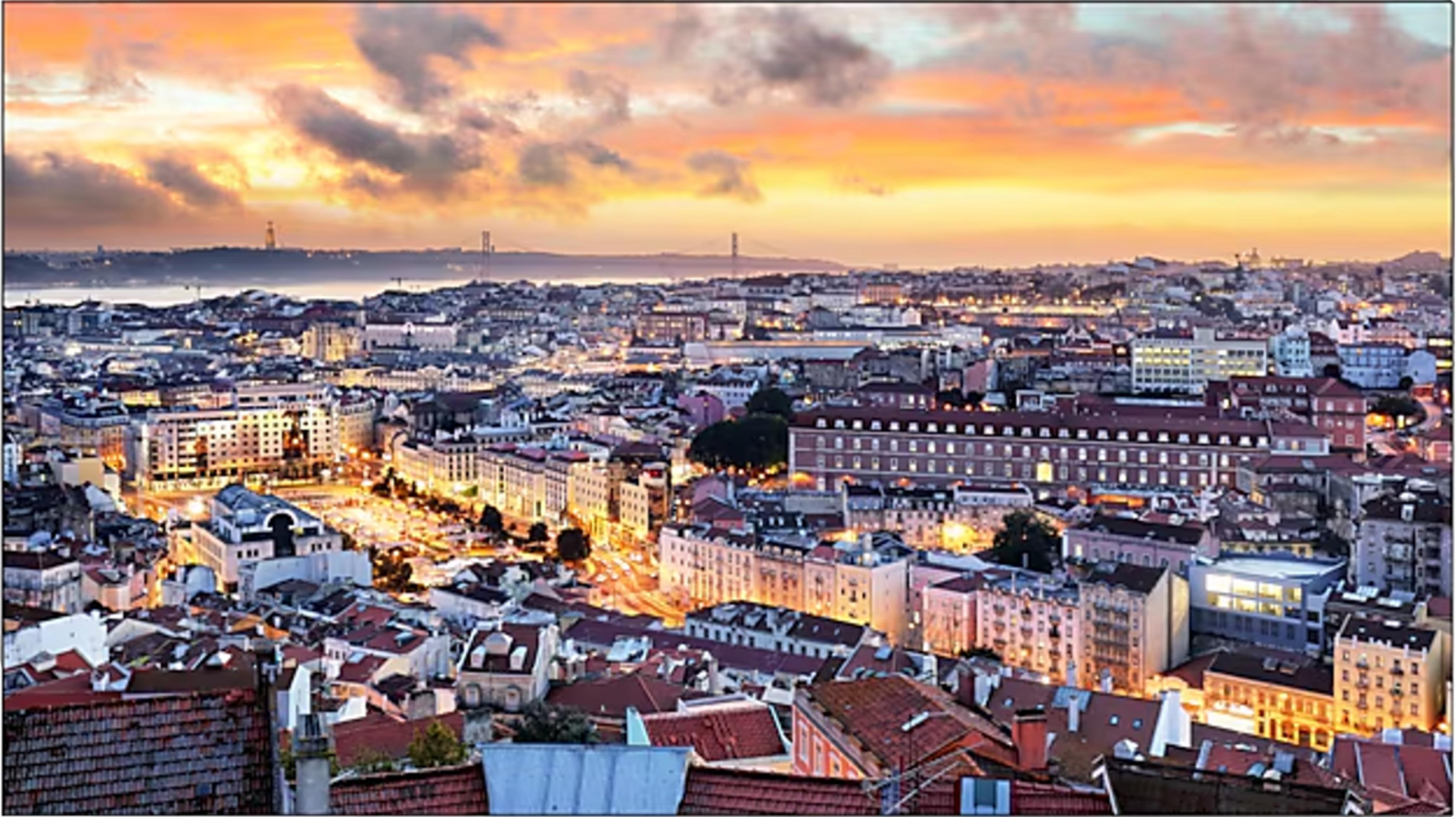 Vista di una città al tramonto con nuvole nel cielo.