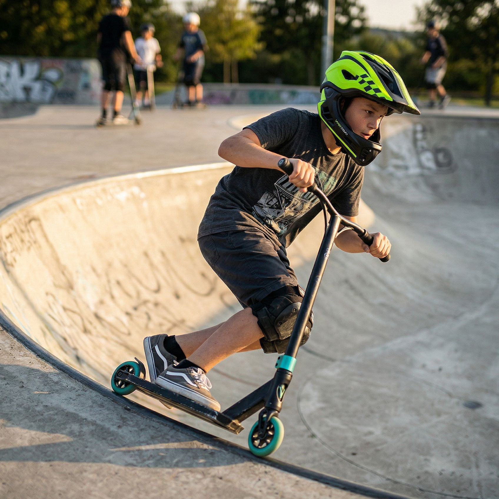 Chłopiec w kasku jeździ na hulajnodze w skateparku.